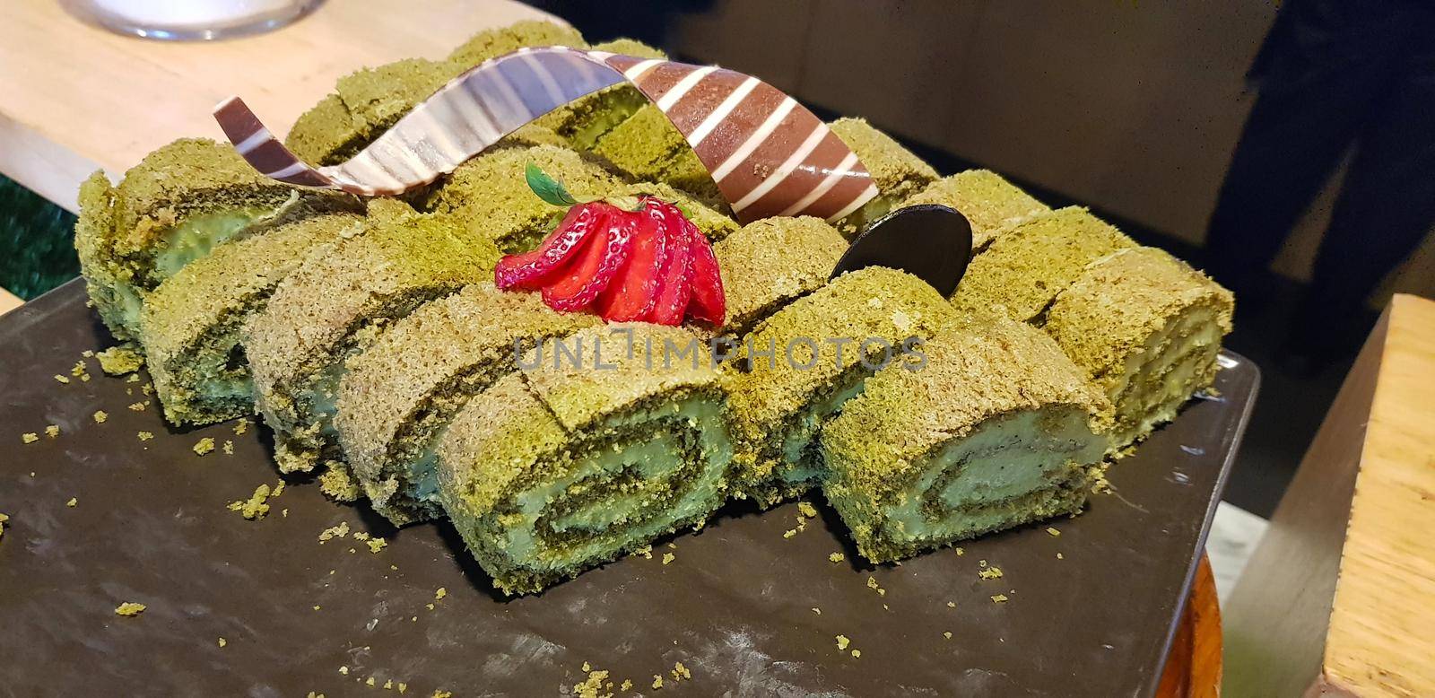 Sponge roll cake with strawberry and chocolate slice and pistachio, food photography concept in fancy restaurant