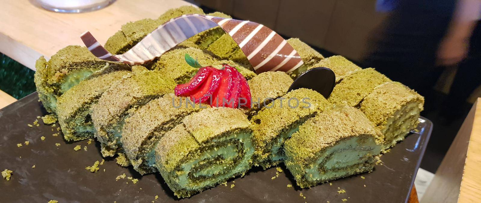 Sponge roll cake with strawberry and chocolate slice and pistachio, food photography concept in fancy restaurant