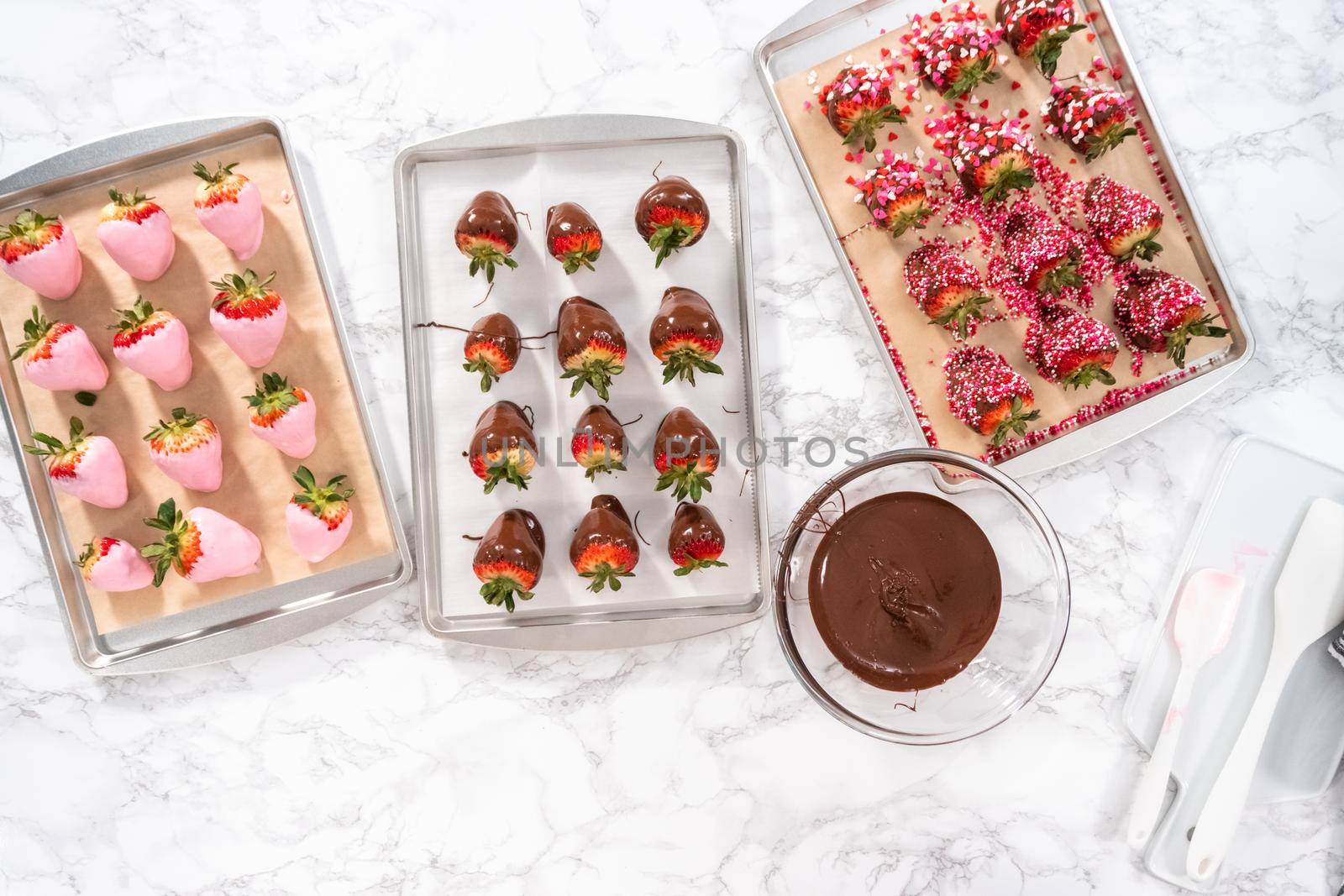 Flat lay. Preparing chocolate covered strawberries on a cookie tray.