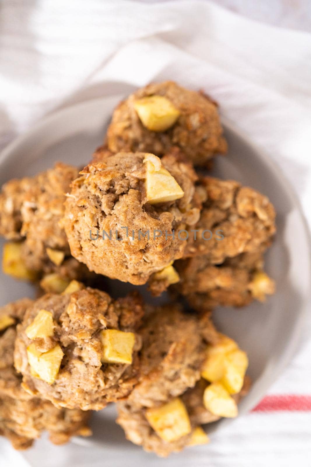 Freshly baked apple oatmeal with apple chunks cookies on small plate.