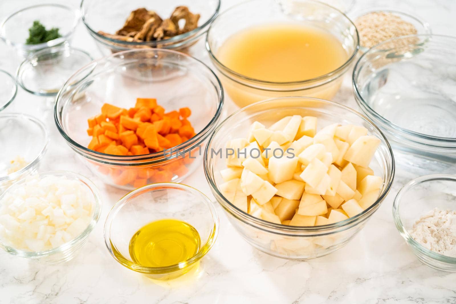 Measured ingredients in a glass mixing bowl to prepare creamy wild mushroom soup.