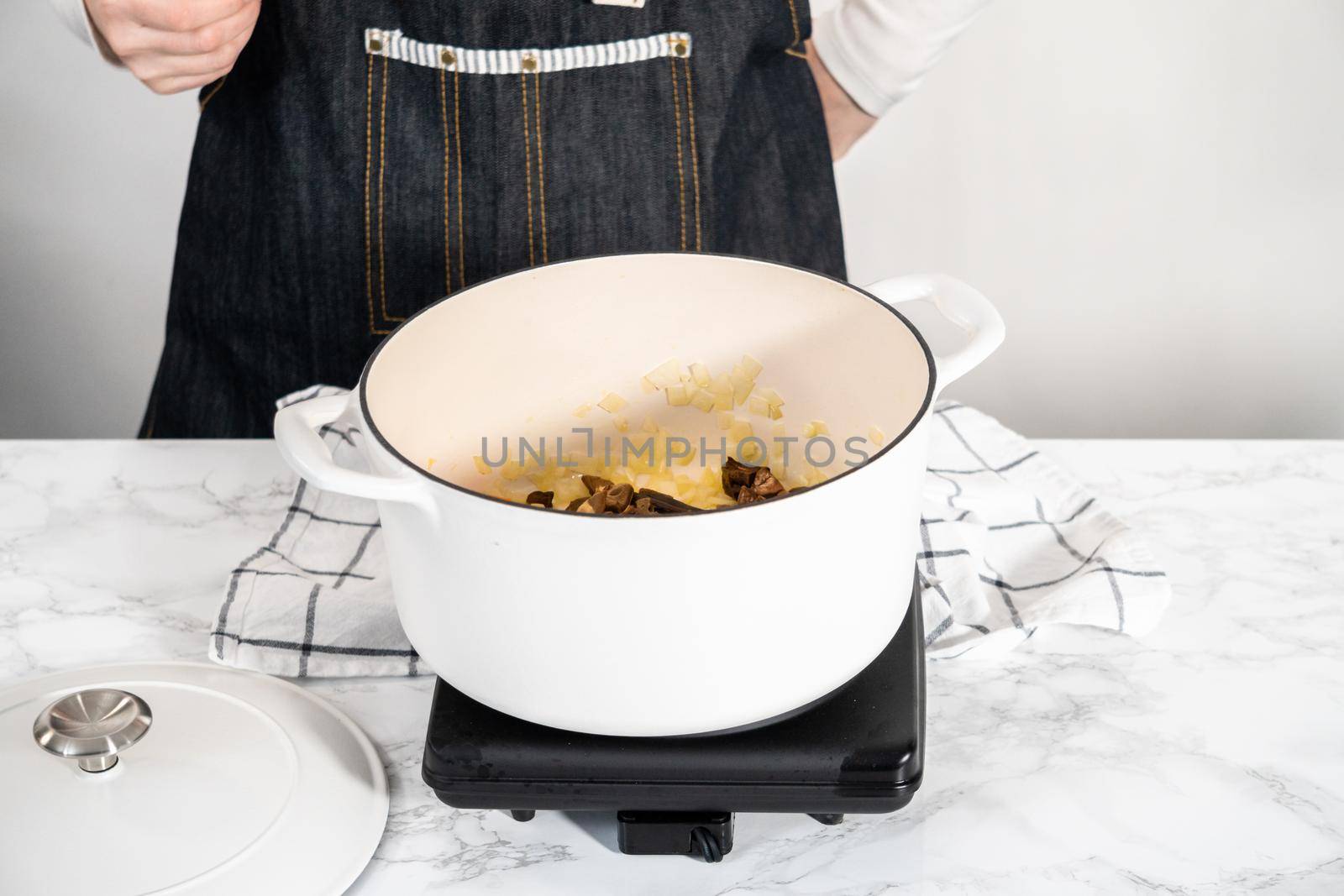 Cooking creamy wild mushroom soup made in an enameled dutch oven.