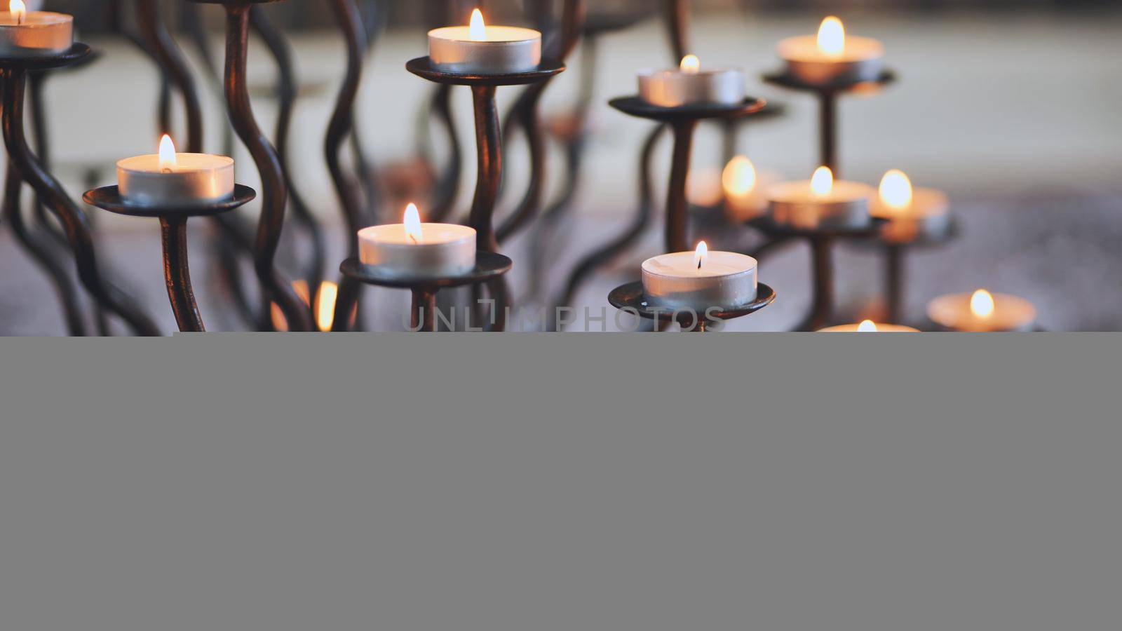 Candlestick holder with burning candles in a Catholic church