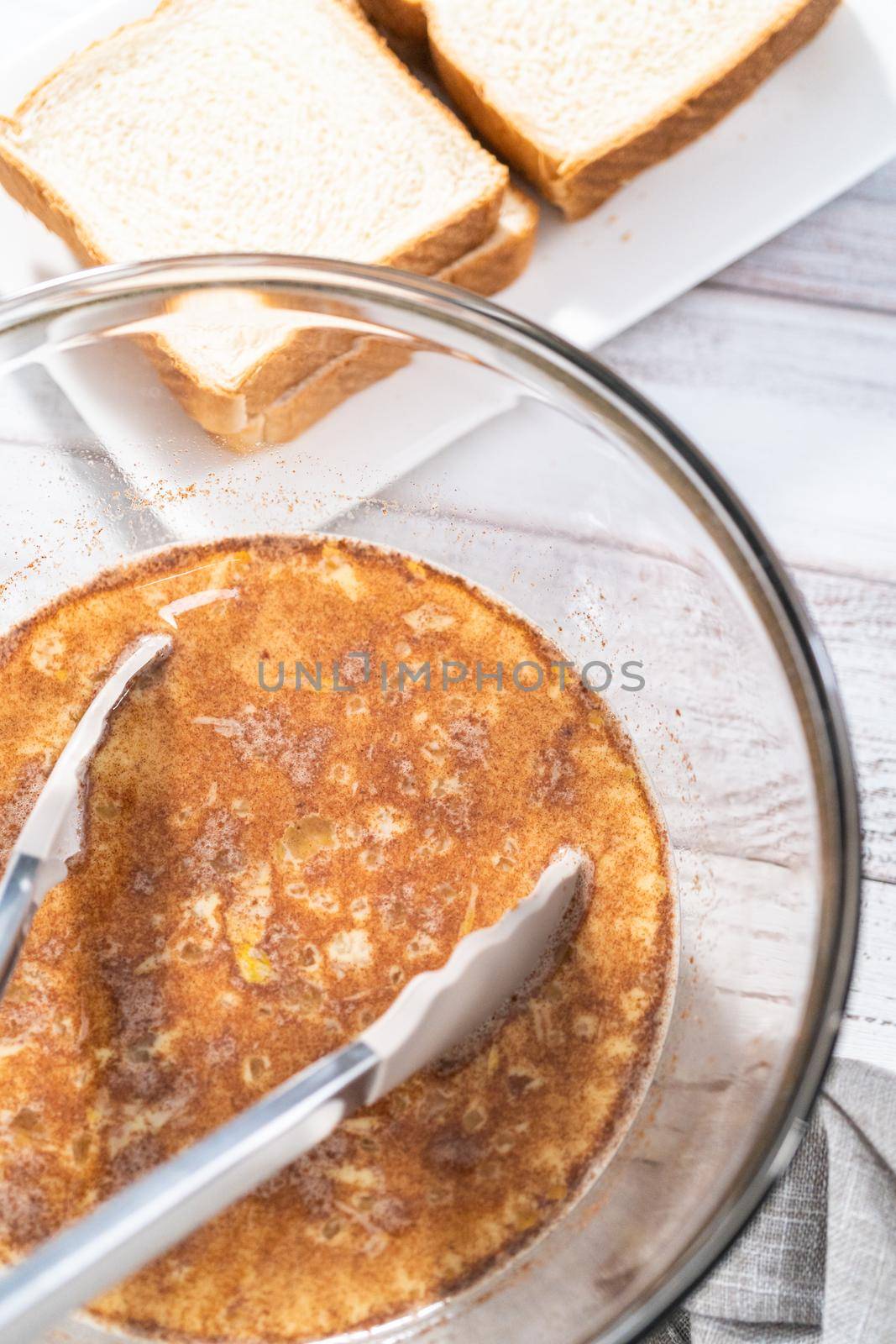 French toast batter in a large glass mixing bowl.