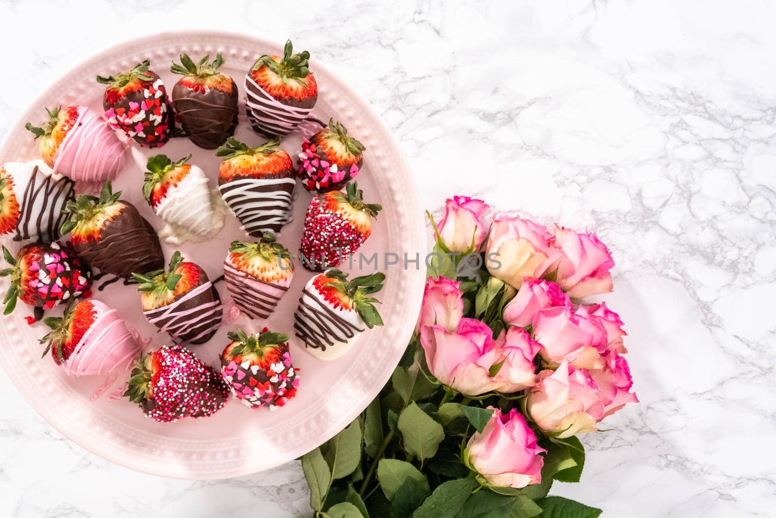 Flat lay. Variety of chocolate dipped strawberries on a pink cake stand.