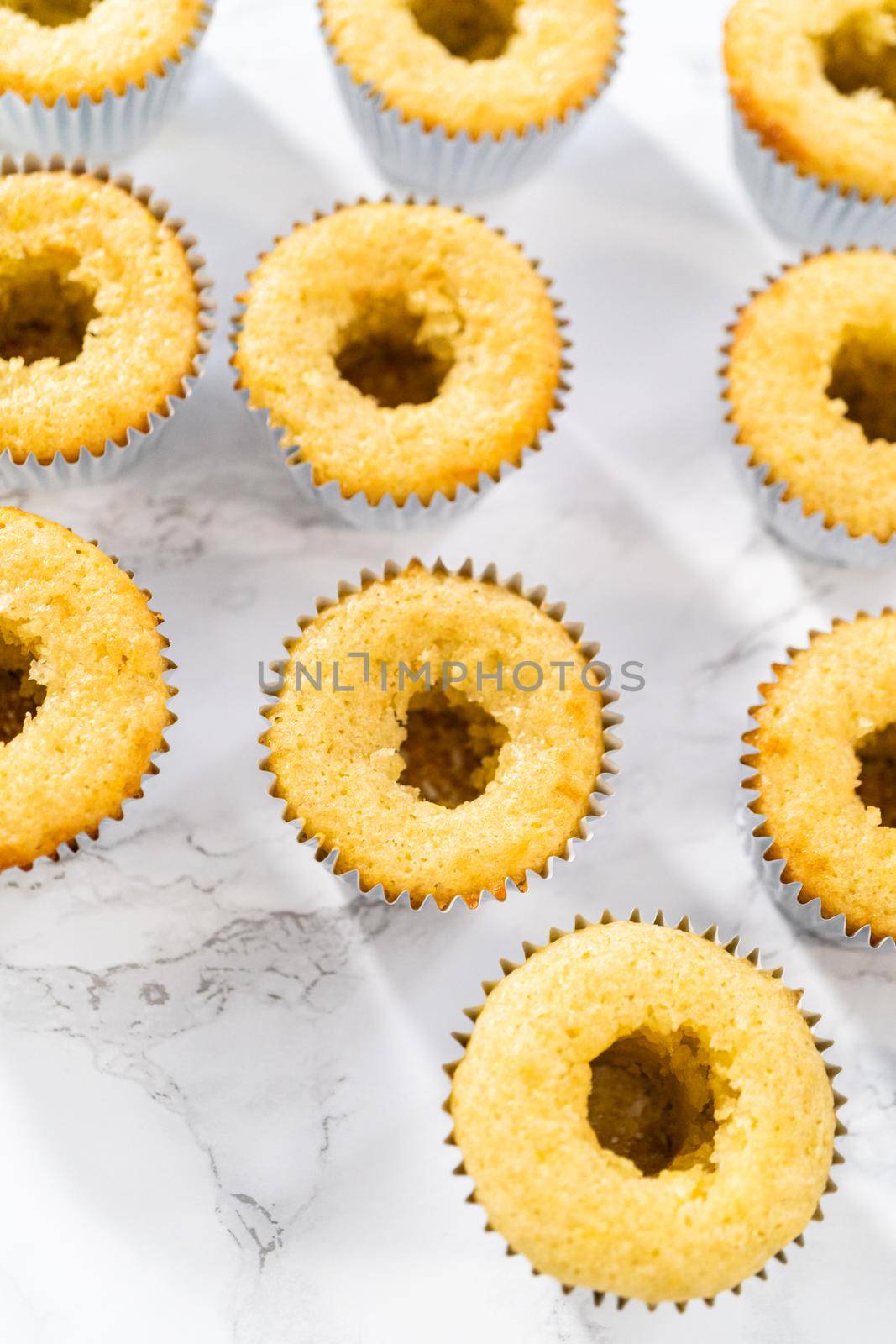 Filling lemon cupcakes with lemon filling.