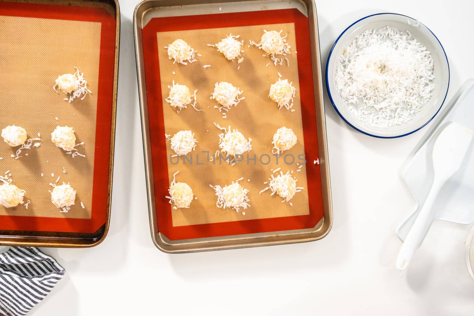 Flat lay. Unbaked dough scoops on the baking sheet to bake coconut cookies.