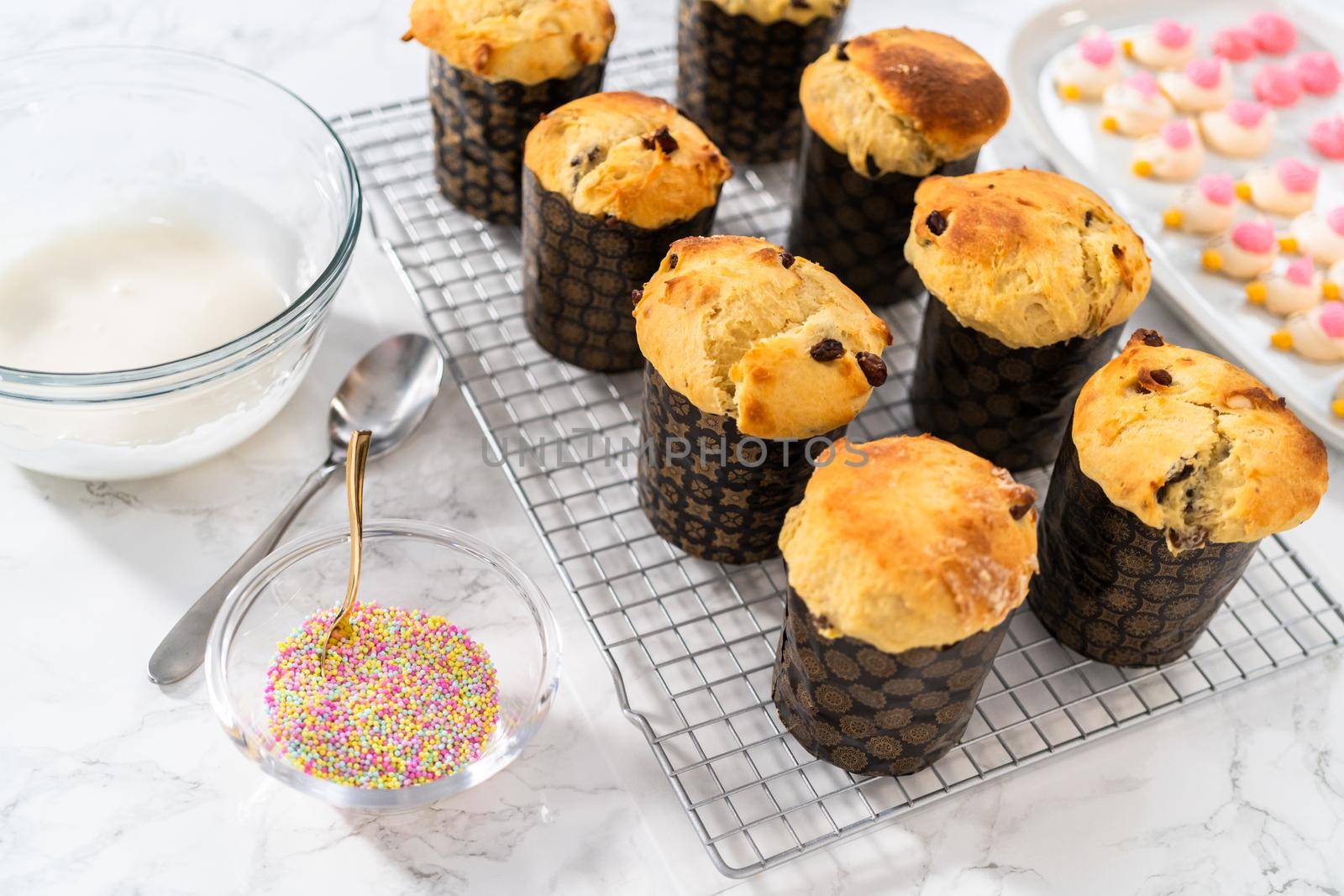 Glazing mini Easter bread kulich with a white lemon glaze.