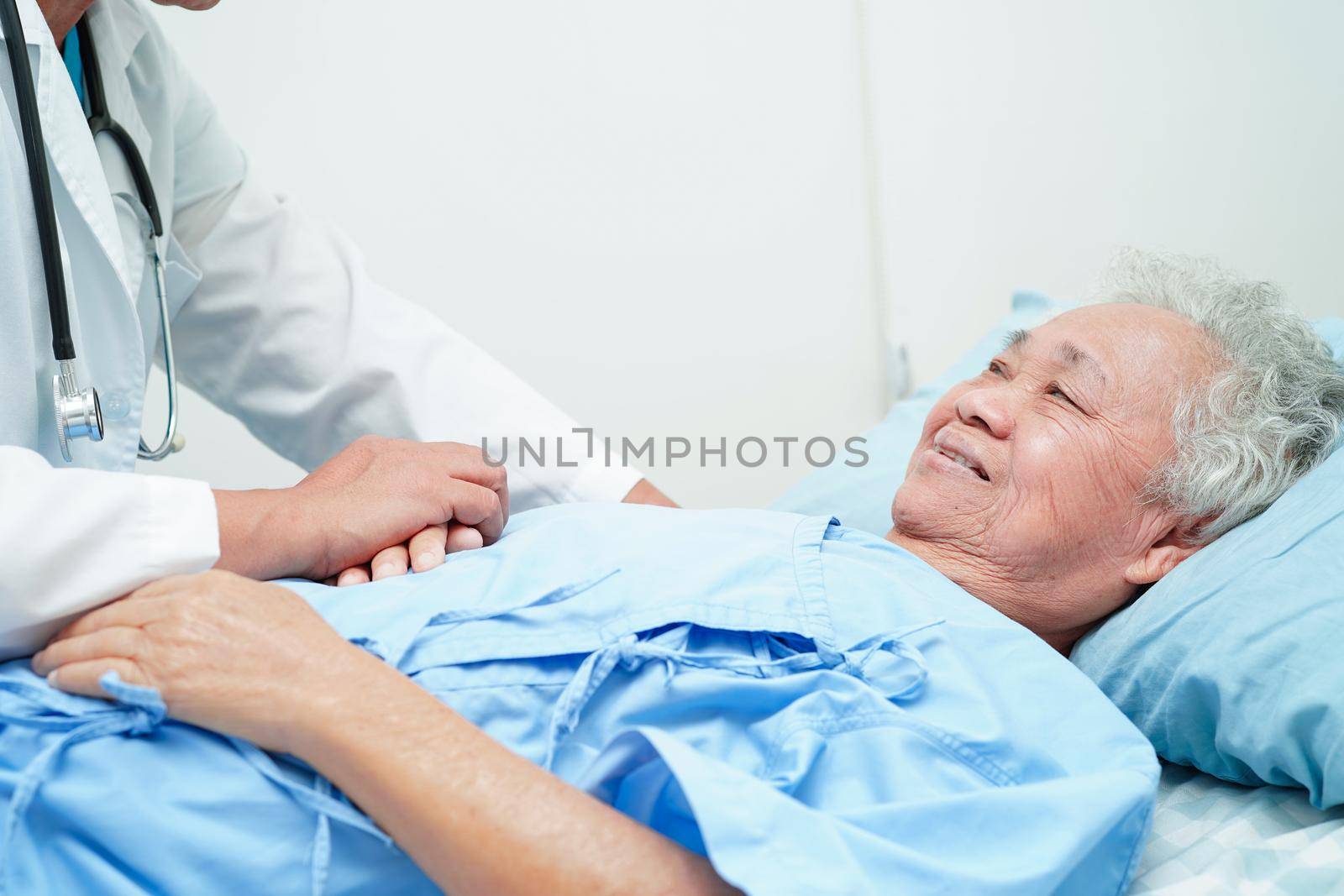 Doctor holding hands Asian elderly woman patient, help and care in hospital.