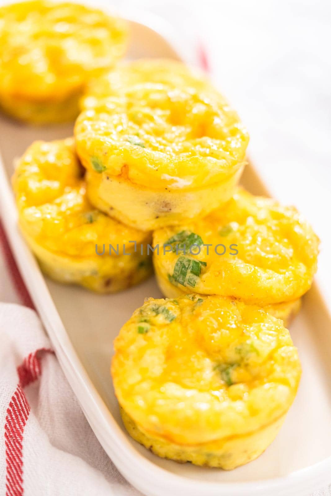 Bacon and cheese egg muffin on a white serving plate.