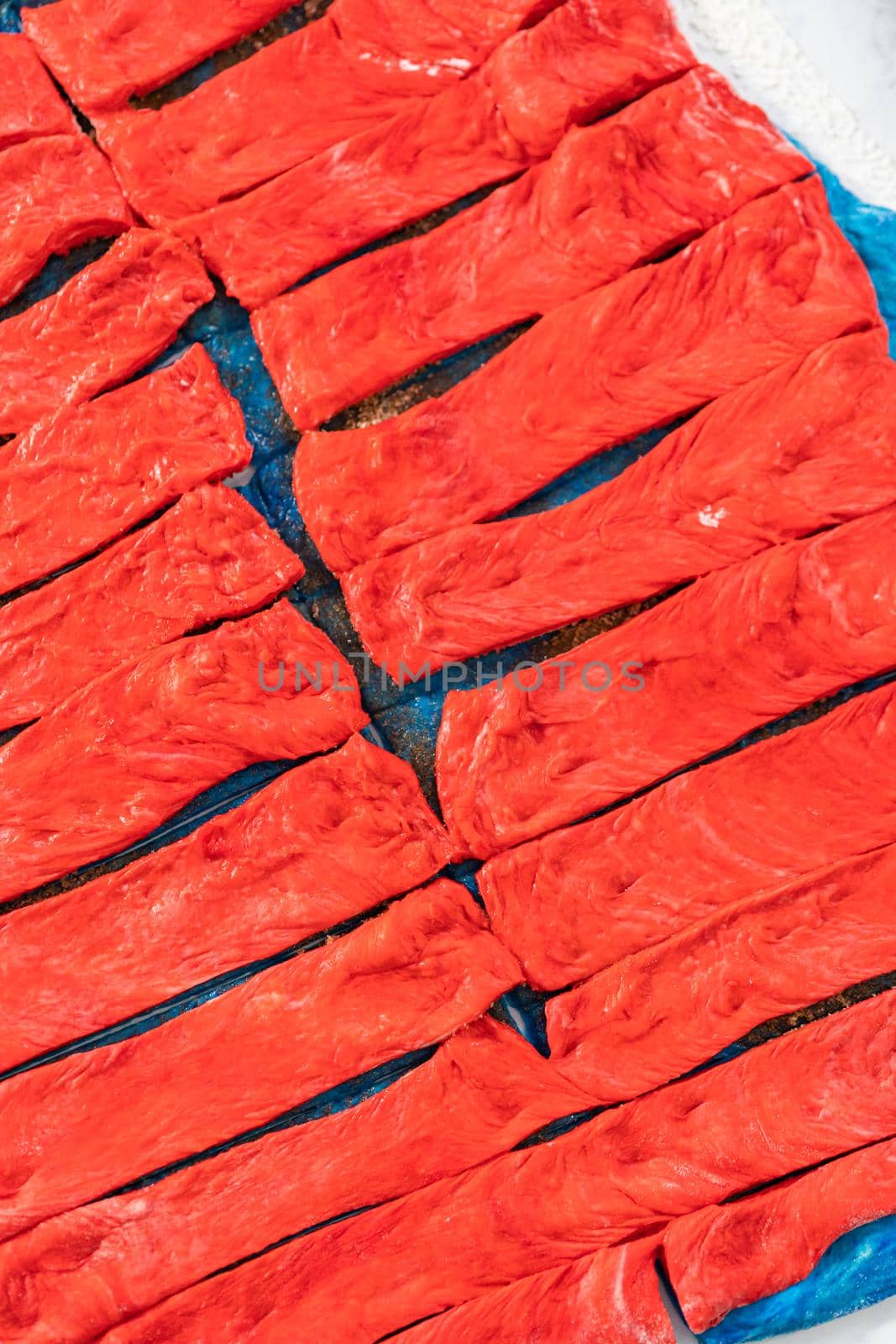 Rolling red and blue bread dough to bake patriotic cinnamon twists.