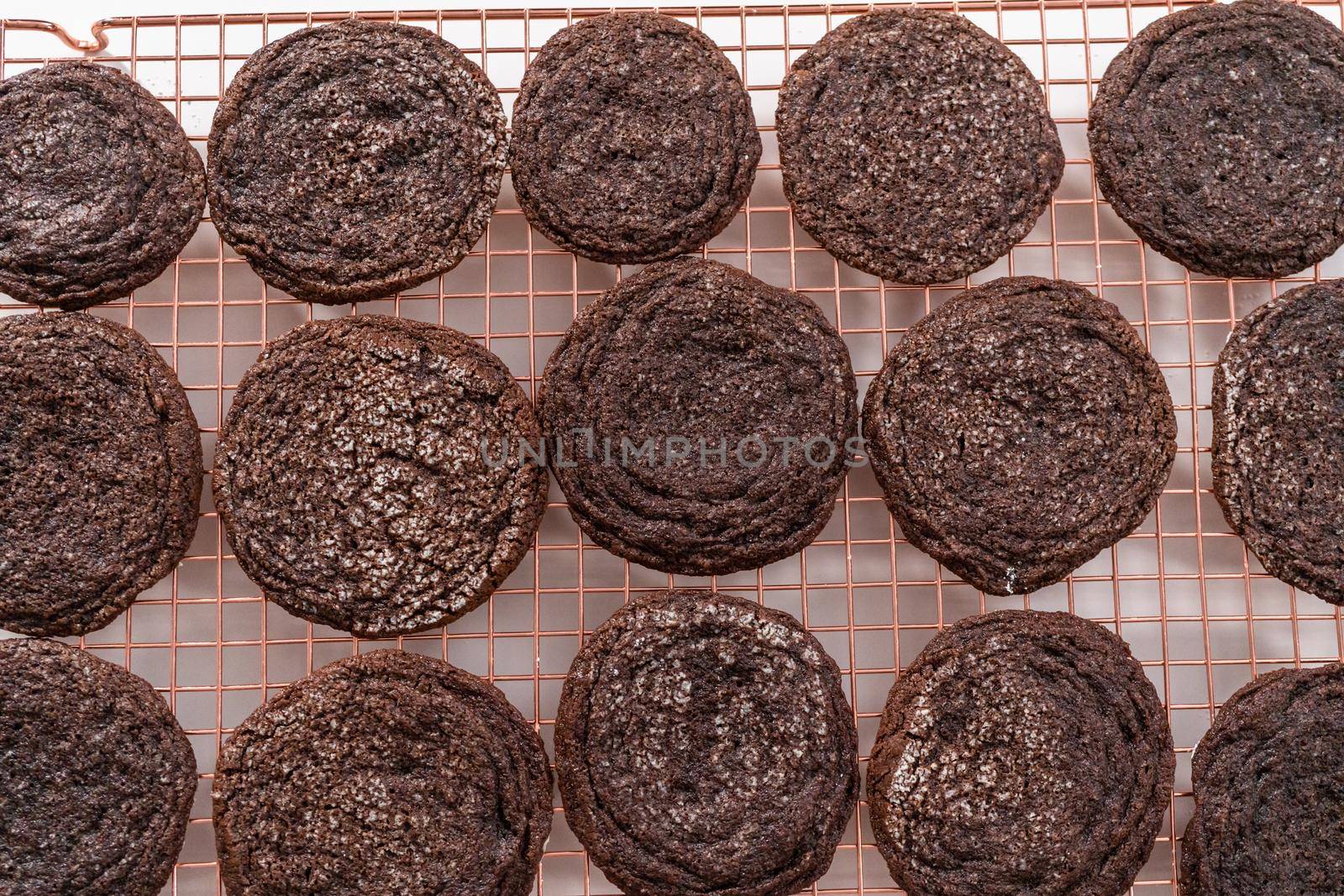 Cooling freshly baked chocolate cookies on a kitchen drying rack.