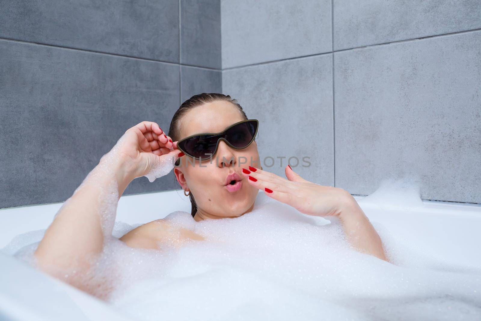 Young woman with sunglasses getting spa treatment in a beauty salon, inside an interior room. Relax in the bathroom without linen. Body care and relaxation concept.
