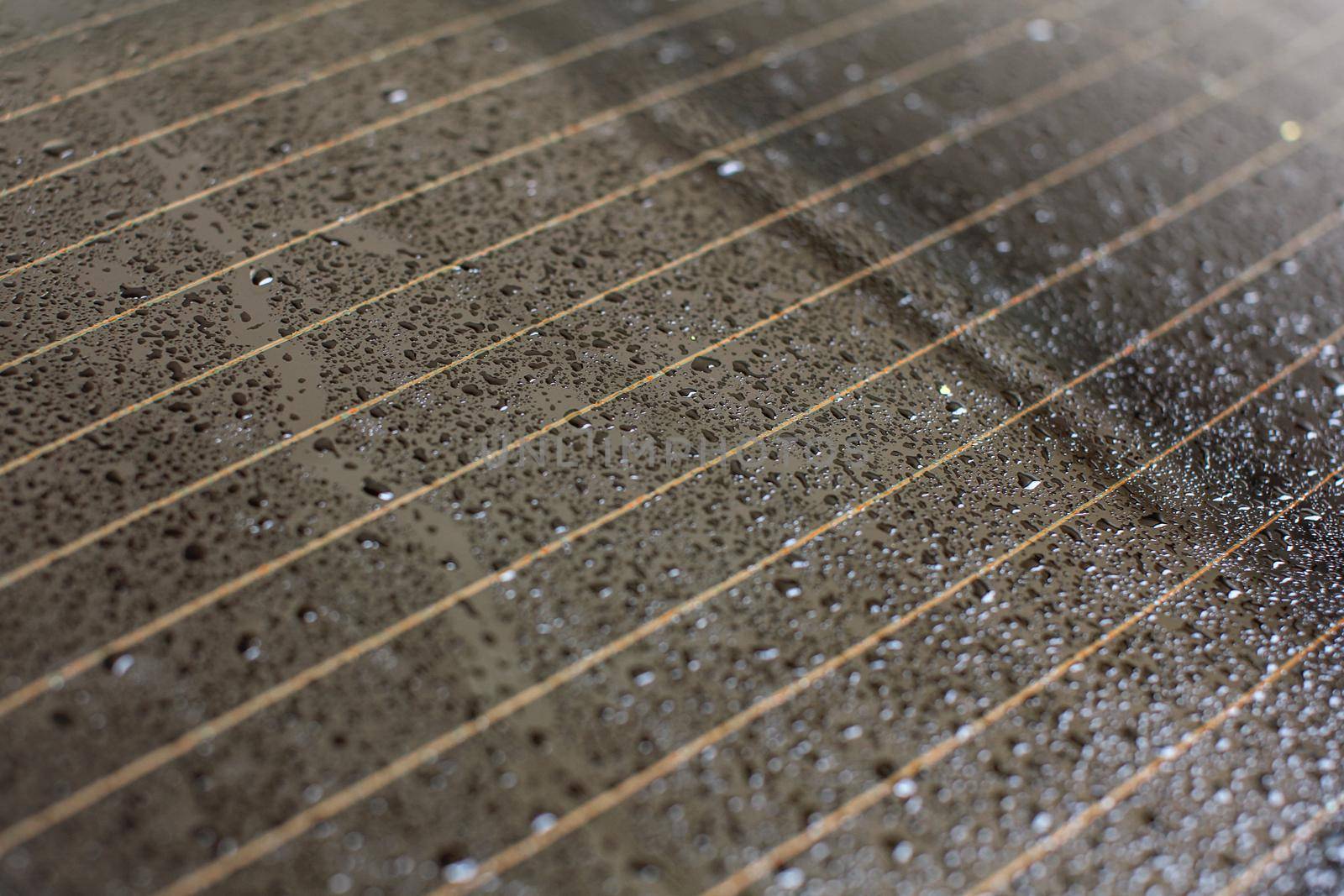 Drops of water on rear car window, orange heating stripes in glass.