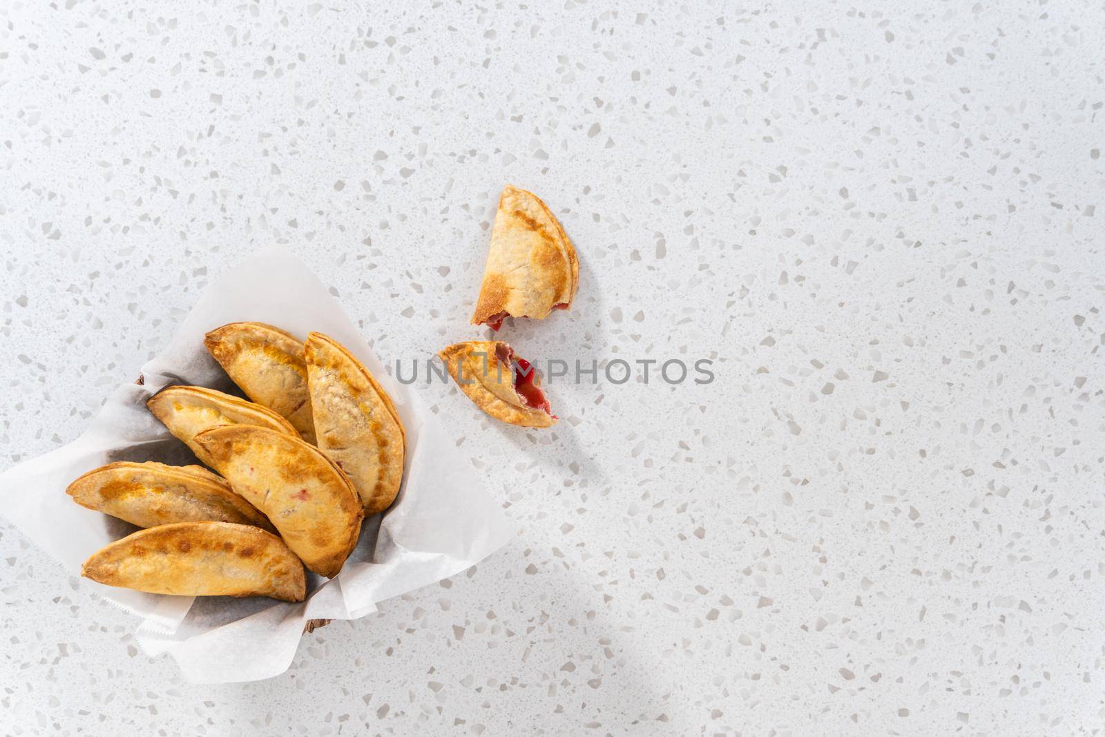 Flat lay. Freshly baked sweet cherry empanadas in the air fryer on the kitchen counter.