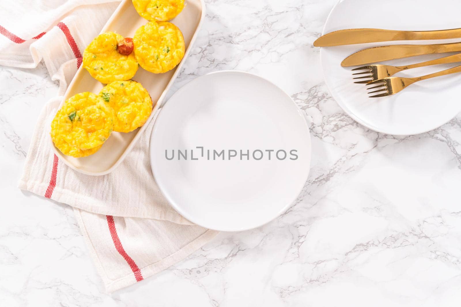 Flat lay. Bacon and cheese egg muffin on a white serving plate.