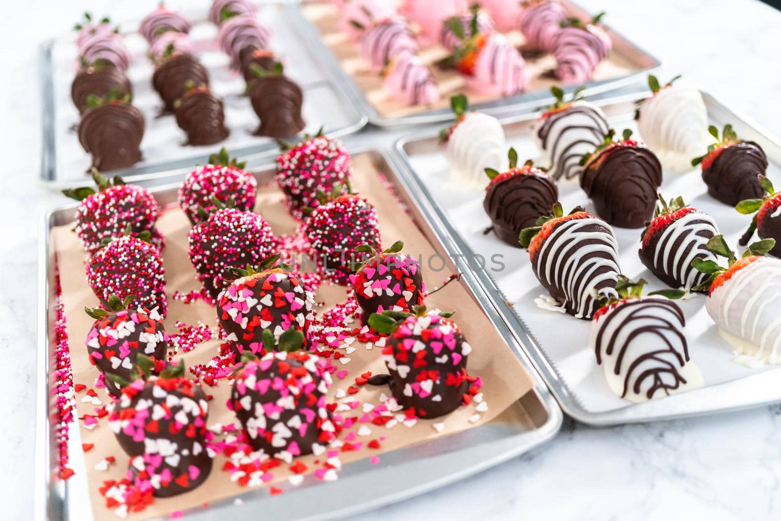 Variety of chocolate dipped strawberries on parchment paper.