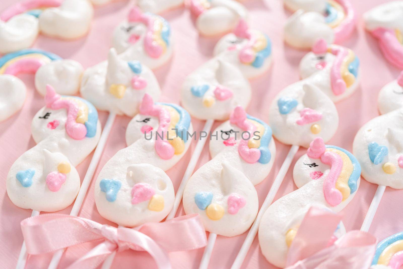Gourmet unicorn theme meringue pops on a pink background.