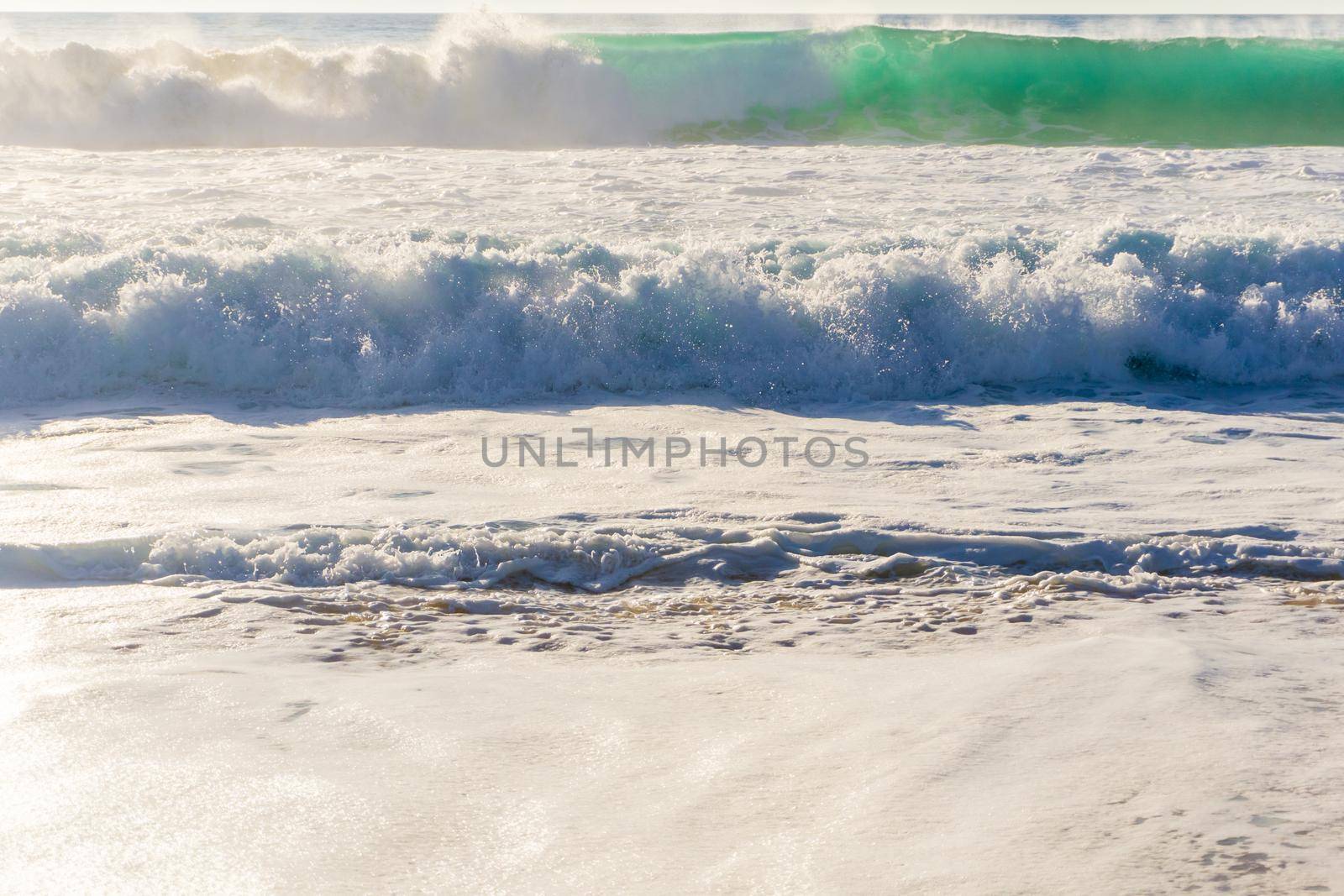 Ocean waves with white foam on a sunny day background