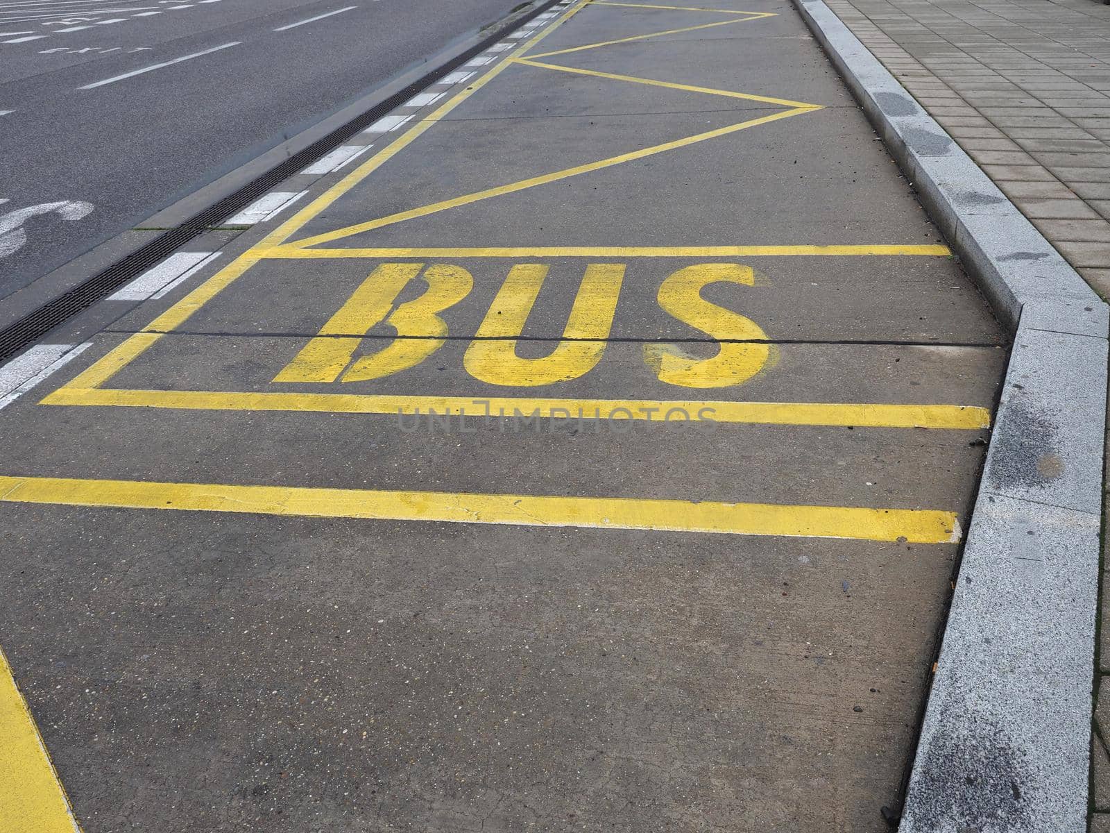 yellow bus stop lane sign on concrete