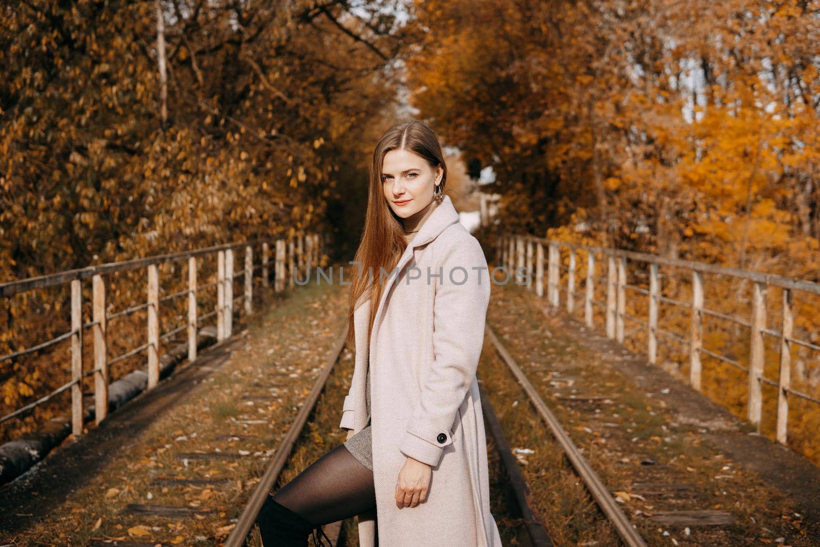 beautiful long-haired woman walks through the autumn streets. Railway, autumn, woman in a coat. by Annu1tochka