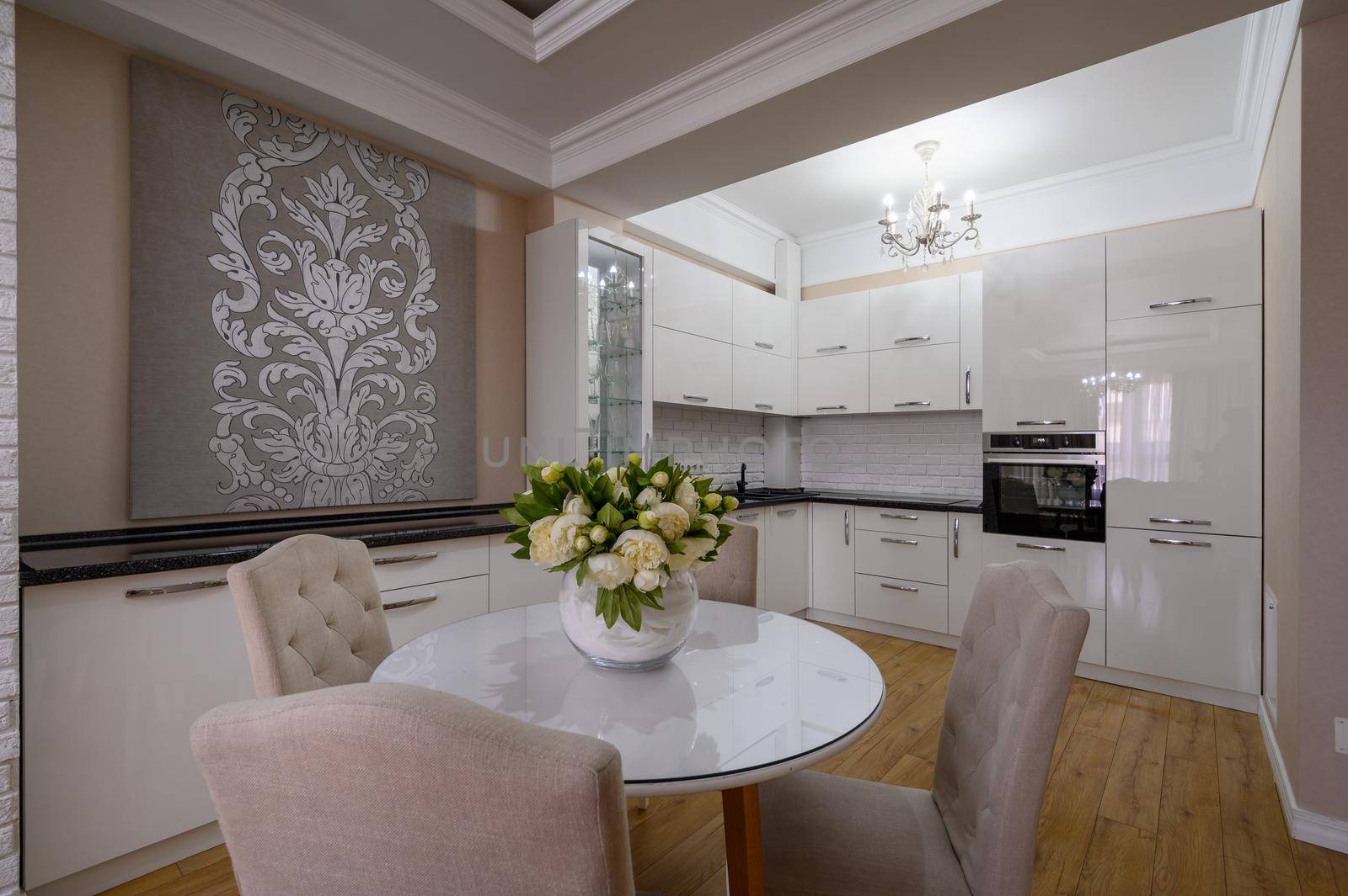 Luxury white modern kitchen with pink and white walls and laminated wooden flooring in studio apartment