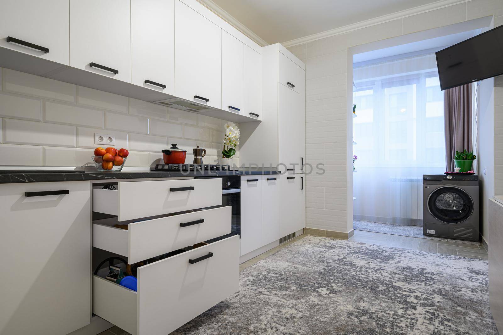 Trendy snow white modern kitchen interior showcase with minimalistic furniture, drawers are retracted