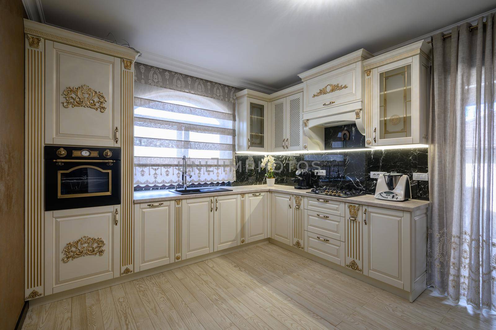 White rich classic cozy kitchen and dining room in city house interior