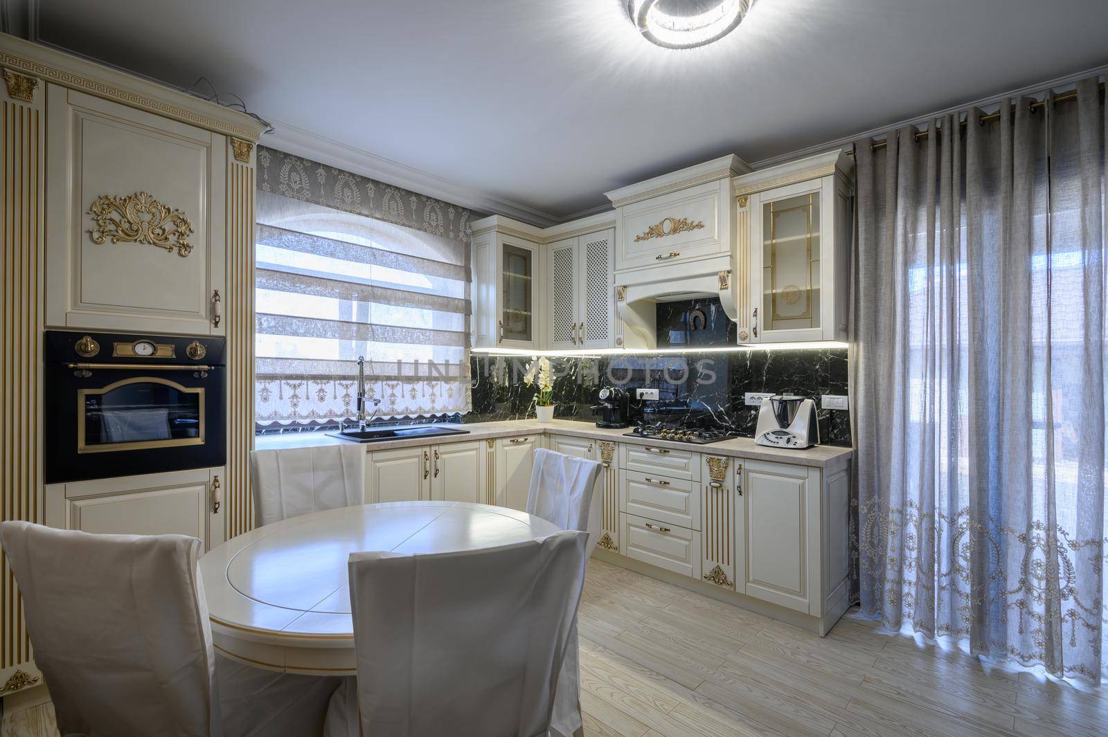 Modern classic white and beige luxurious kitchen with dining room in studio apartment interior