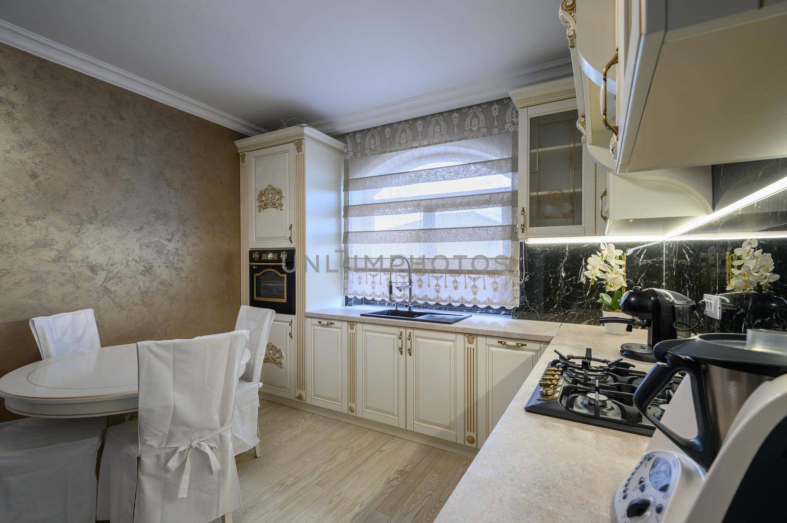 Modern classic white and beige luxurious kitchen with dining room in studio apartment interior