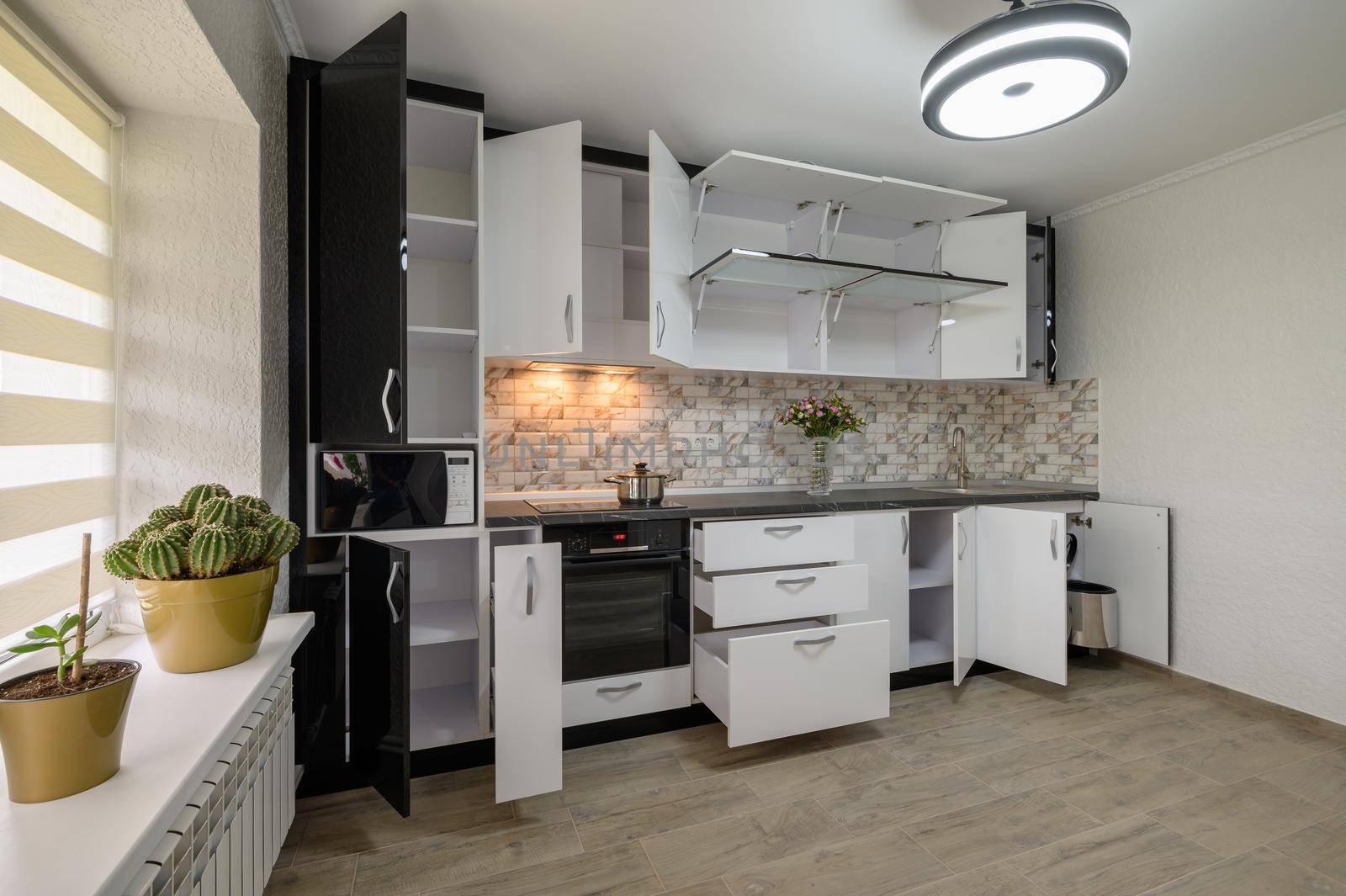 Interior renovation showcase of well designed modern trendy white kitchen, cabinet doors open, drawers retracted