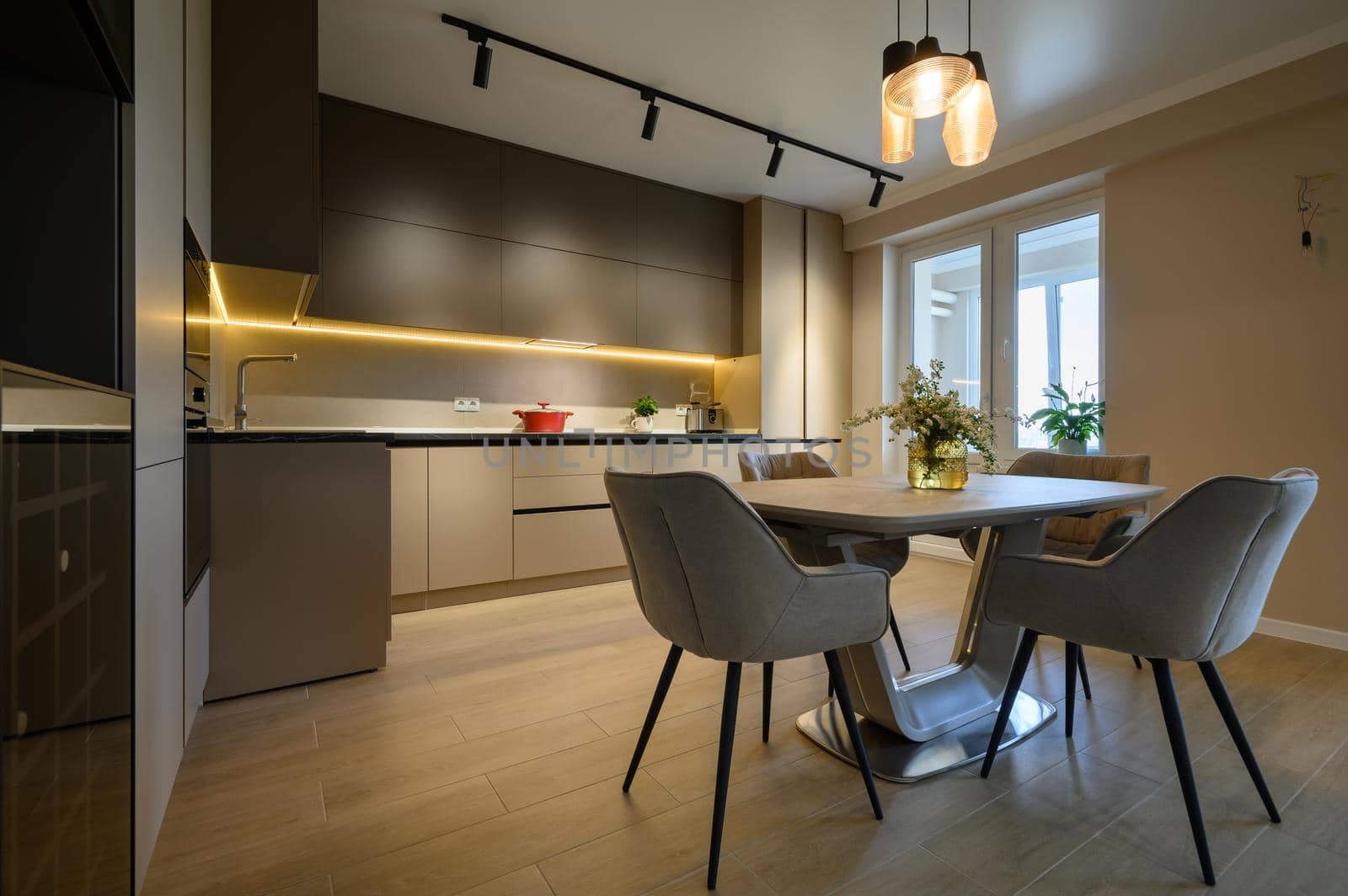 Modern grey luxurious kitchen in studio apartment interior, closeup to dining table