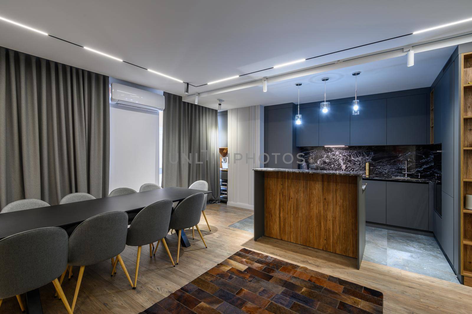 Luxury living room with dining or banquet table and grey kitchen in studio apartment interior