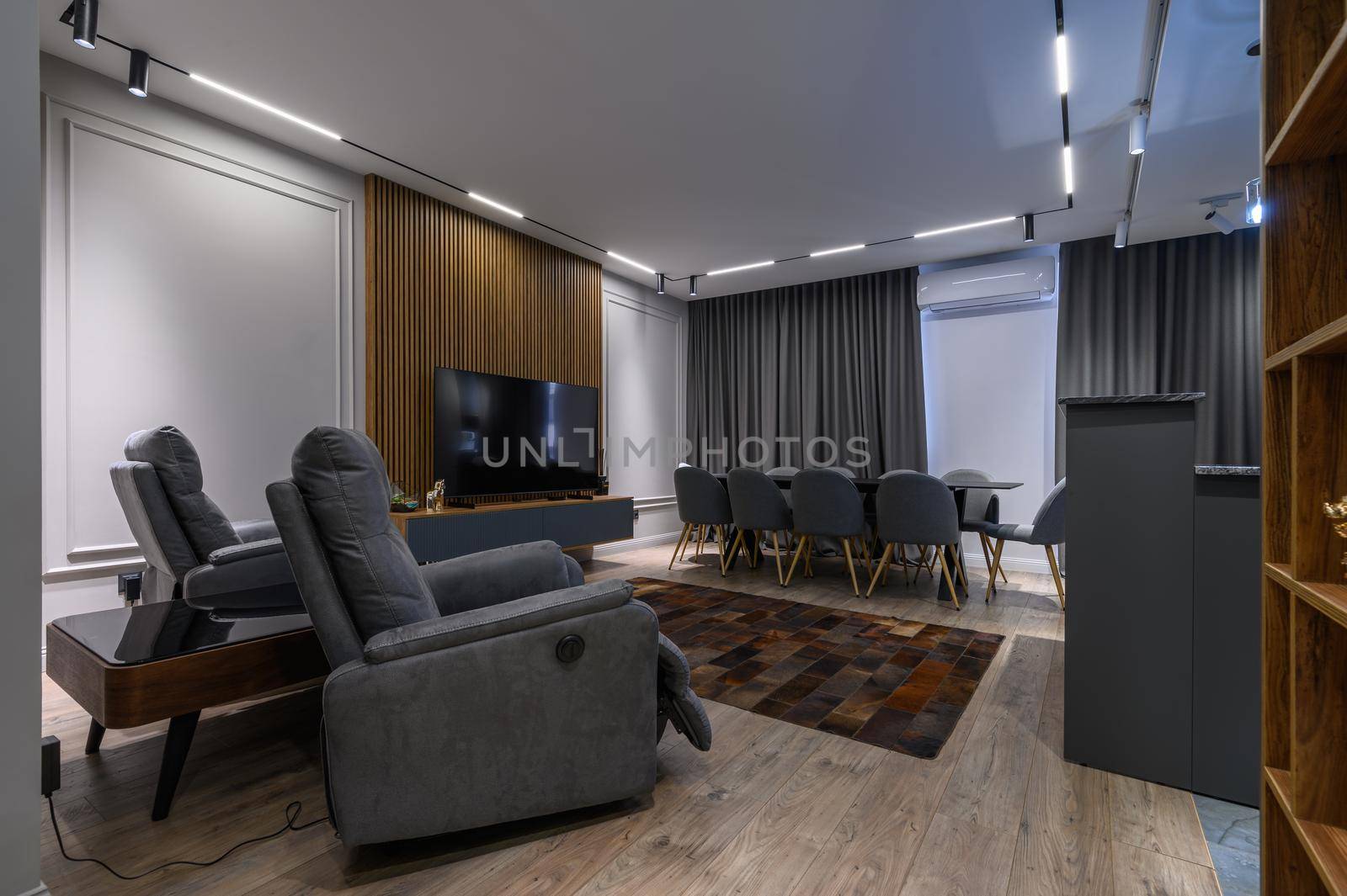 Luxury living room with massage chairs and grey kitchen in studio apartment interior