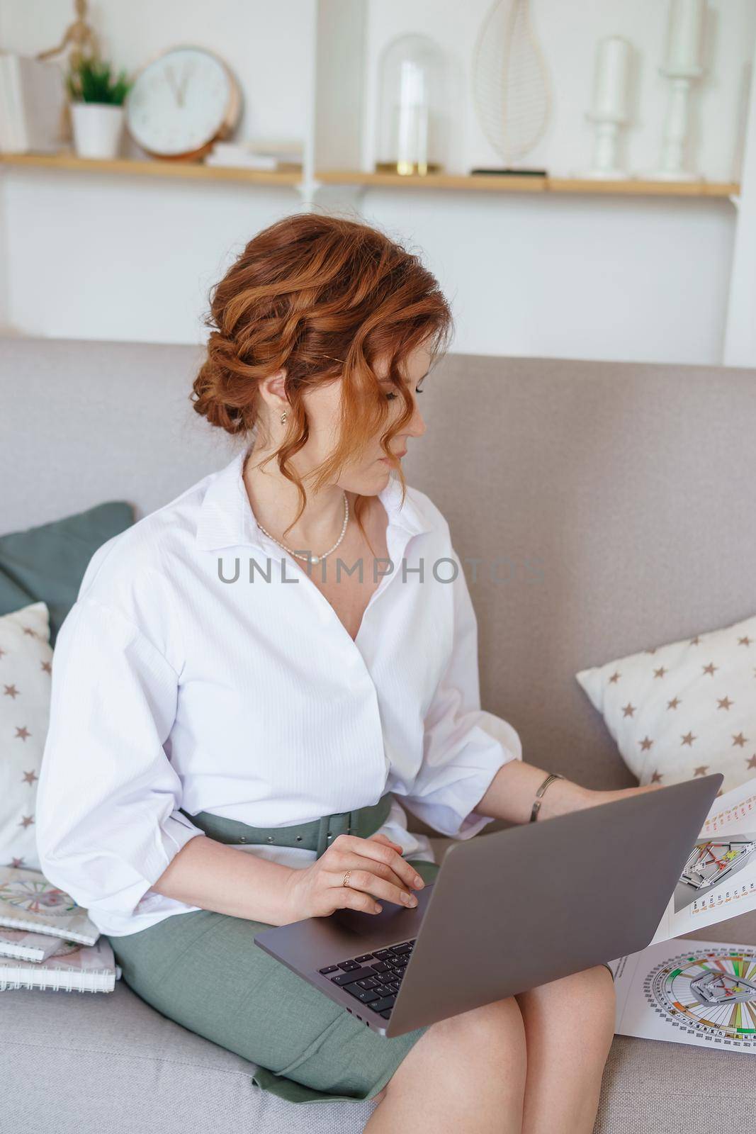 Tver, Russia-July 31, 2022 A woman with a laptop is studying human design. The concept of studying esoteric sciences. Studying rave postcards from human design.