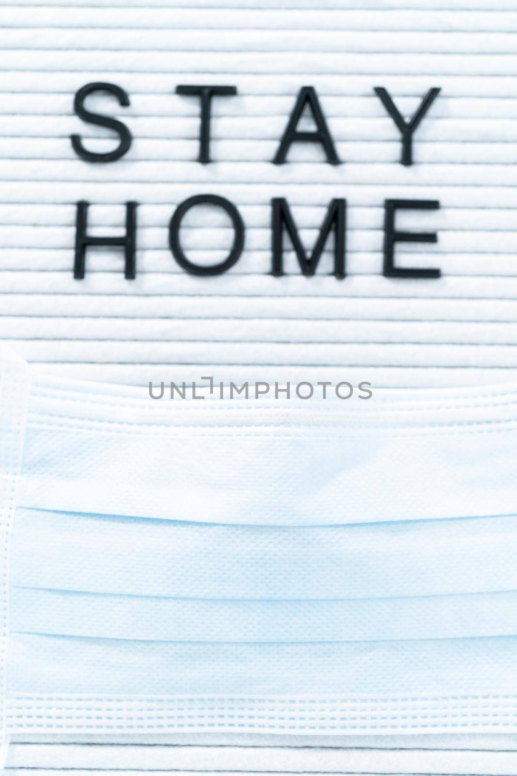 STAY HOME sign on message board with a blue medical mask.