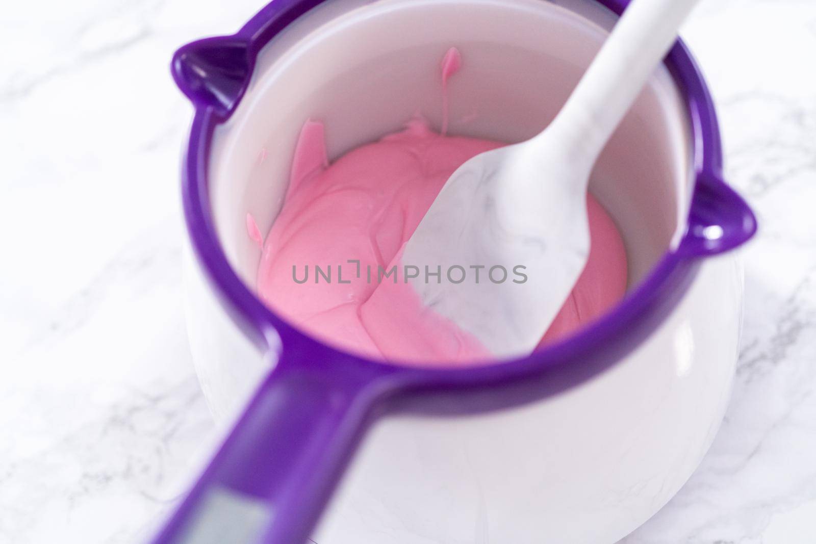 Melting chocolate melts in a candy melting pot to prepare hot chocolate bombs.
