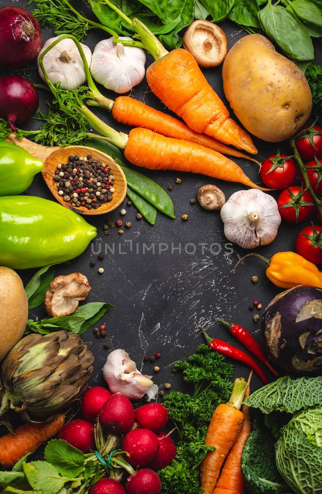 Top view of fresh farm organic vegetables, herbs and wooden spoon on rustic black concrete background. Autumn harvest, local market or clean healthy eating concept with space for text