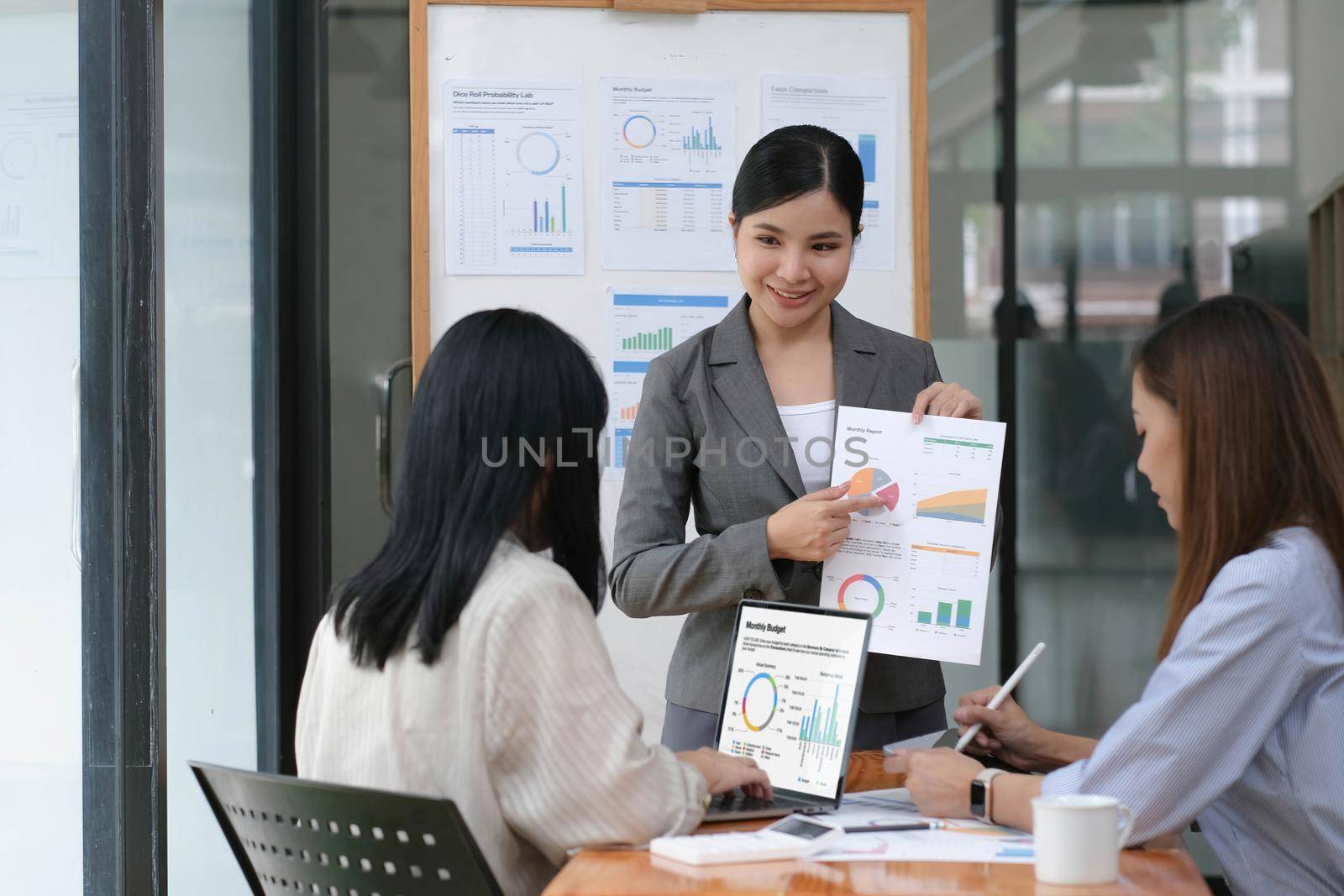 Asian woman lead group of young Asian business creative team in brainstorm meeting presentation. Girl power, colleague coworker partnership teamwork, people cooperation, or idea sharing concept by wichayada