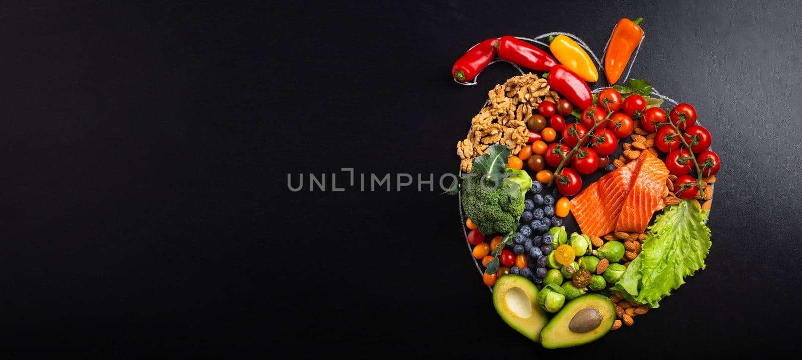 Healthy diet and nutrition for heart and cardiovascular system, healthy food, fruit and vegetables arrangement in realistic heart shape on black chalk board top view composition with copy space.