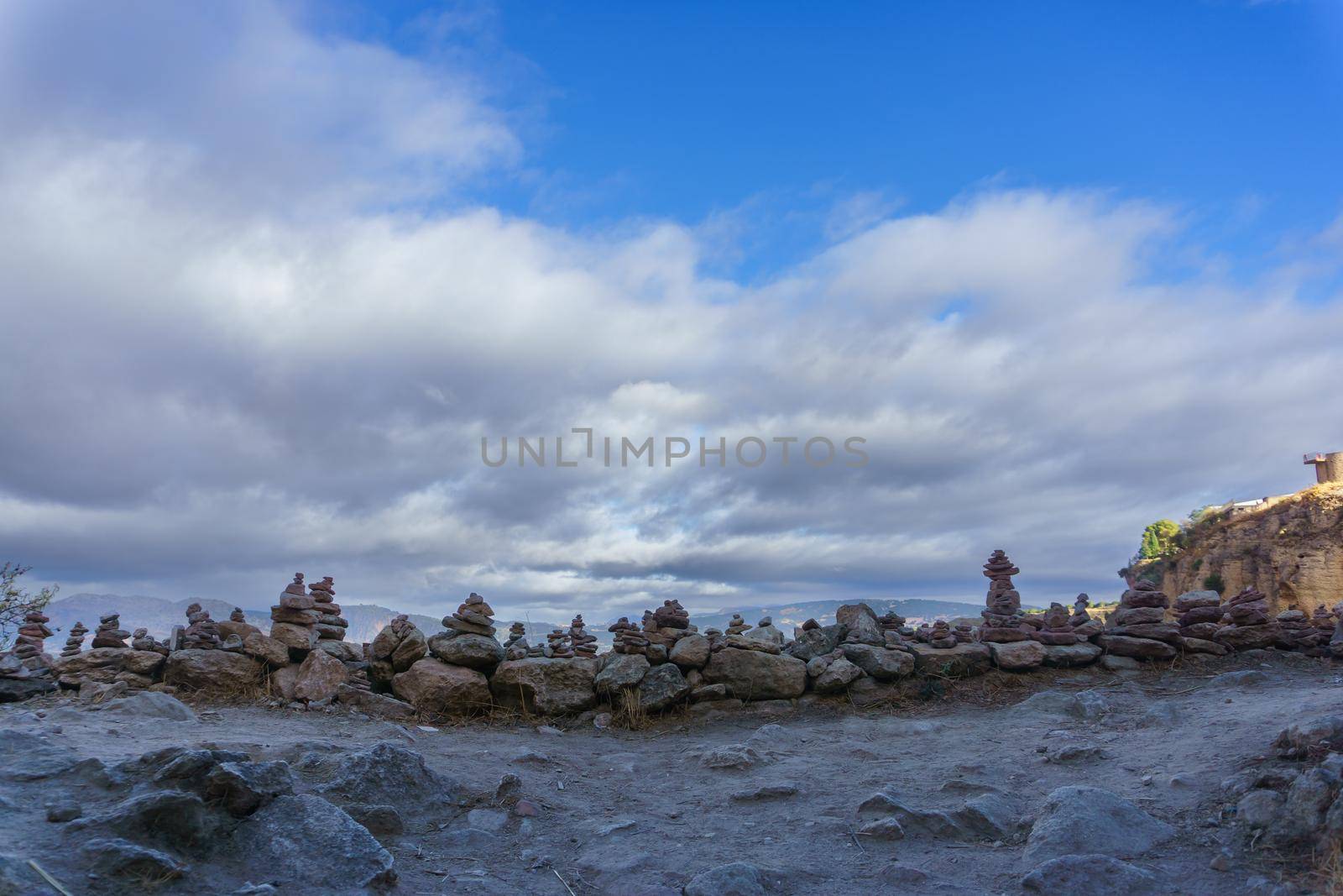 stacked stone monticule sky with clouds by joseantona