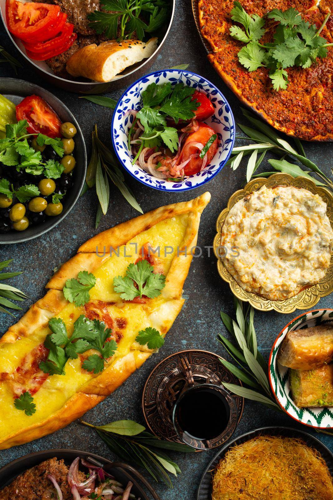 Traditional Turkish food, assorted dishes and mezze appetizers on rustic background from above. Pide, Lahmacun, meat kebab, Turkish meatballs, sweet baklava and Kunefe. Middle East cuisine, top view