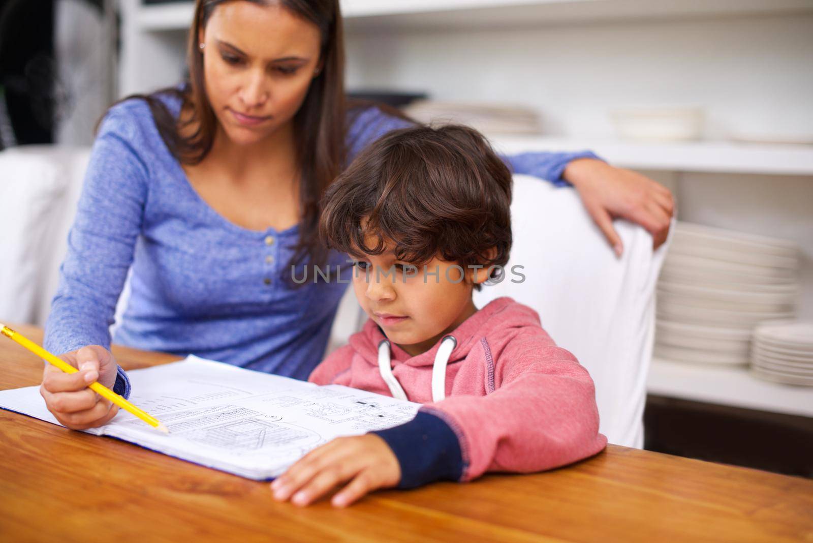 Education starts at home. a mother helping her son with his homework