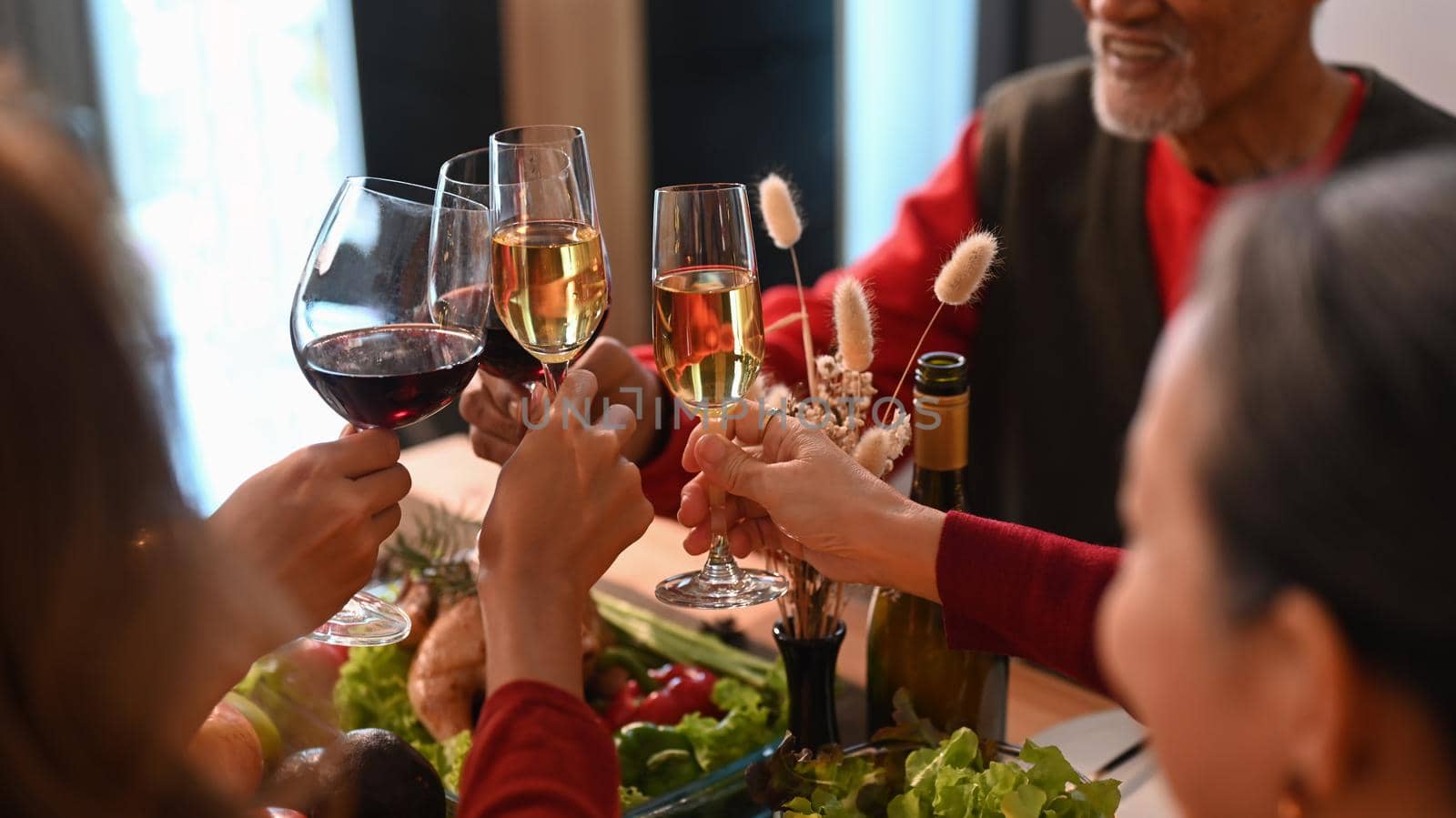 Extended family toasting wine during celebrating Christmas dinner. Holidays and celebration concept.