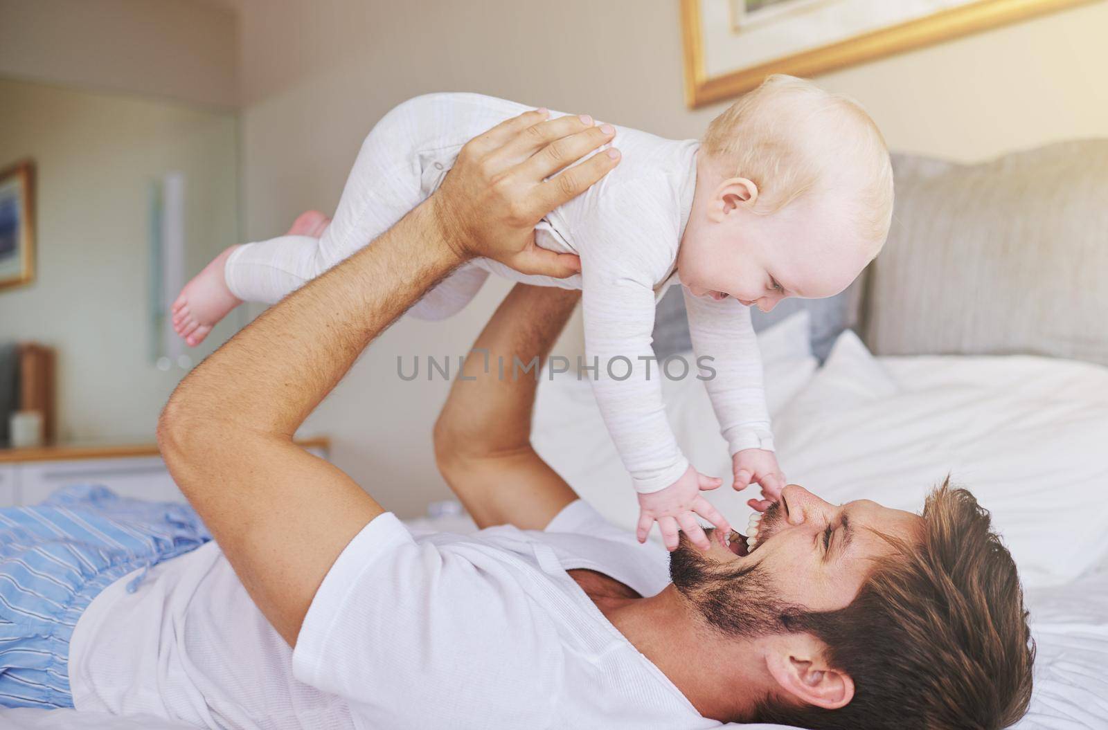 Lifting up his daughter. a young father and his baby daughter in the bedroom