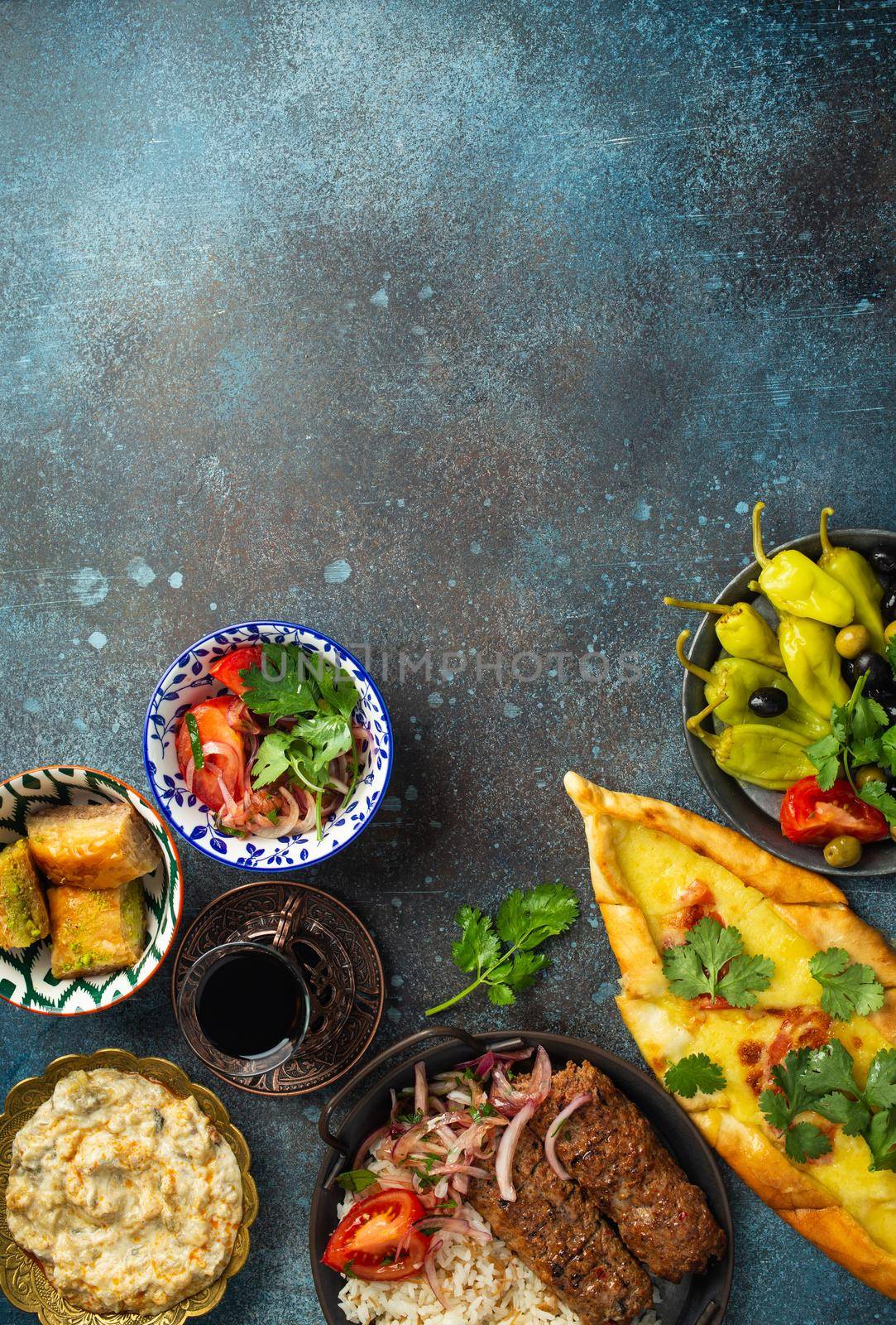 Traditional Turkish food, assorted dishes and mezze appetizers on rustic background from above. Pide, Lahmacun, meat kebab, Turkish meatballs, sweet baklava and Kunefe. Middle East cuisine, copy space