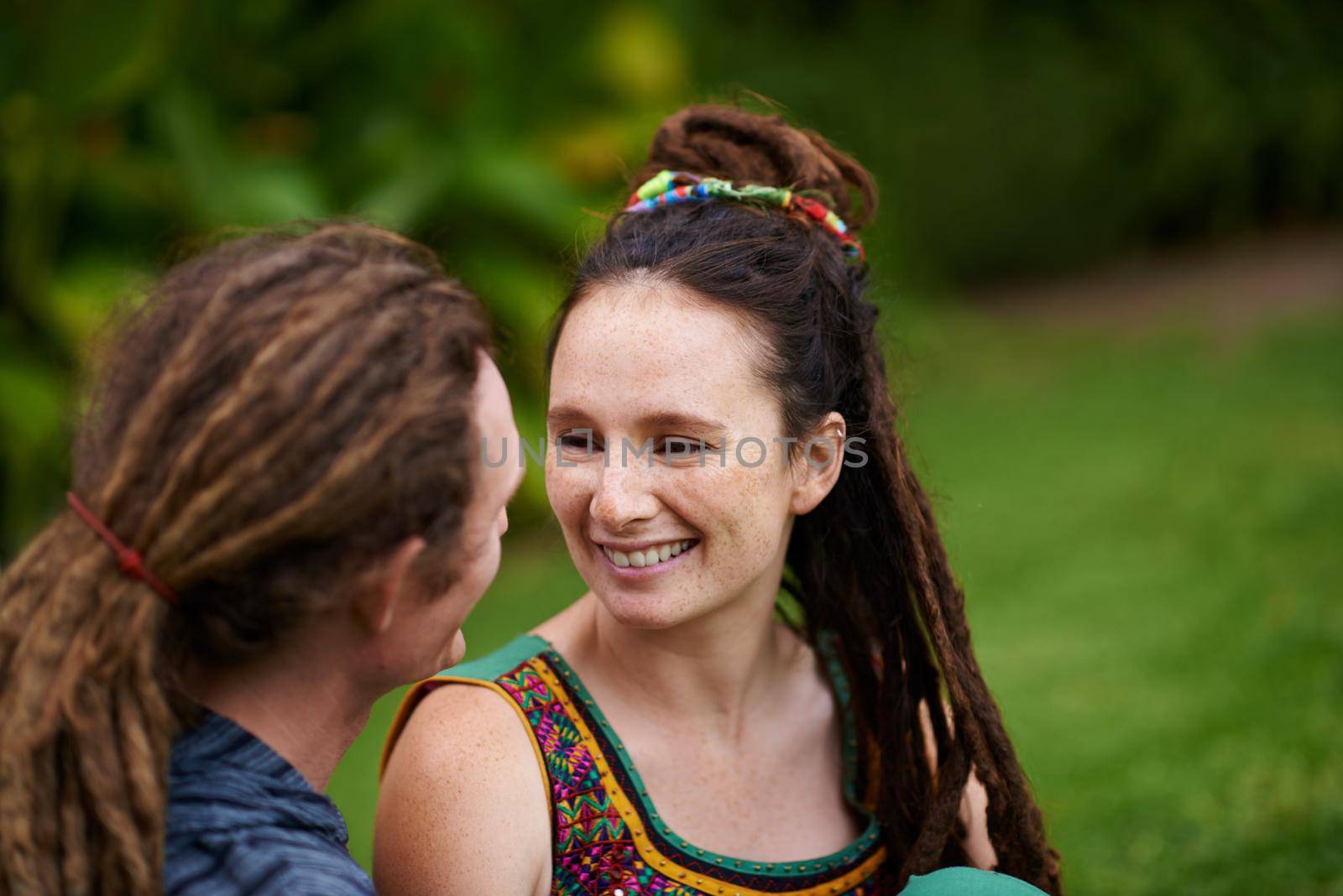 Their connection is undeniable. a young hippie couple outdoors. by YuriArcurs