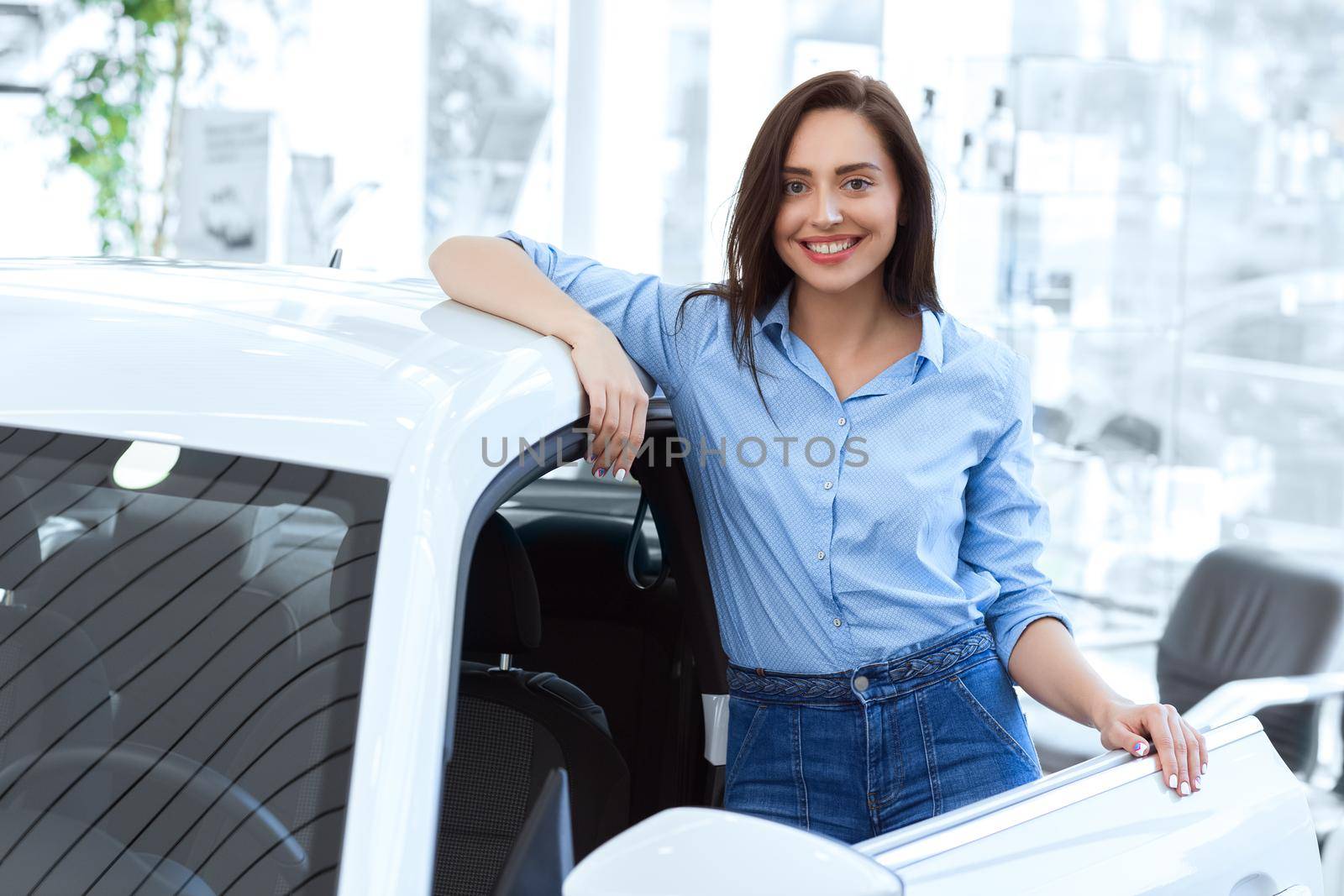 Taking it for a spin! Shot of an attractive young woman posing near her newly bought car at the car dealership copyspace on the side
