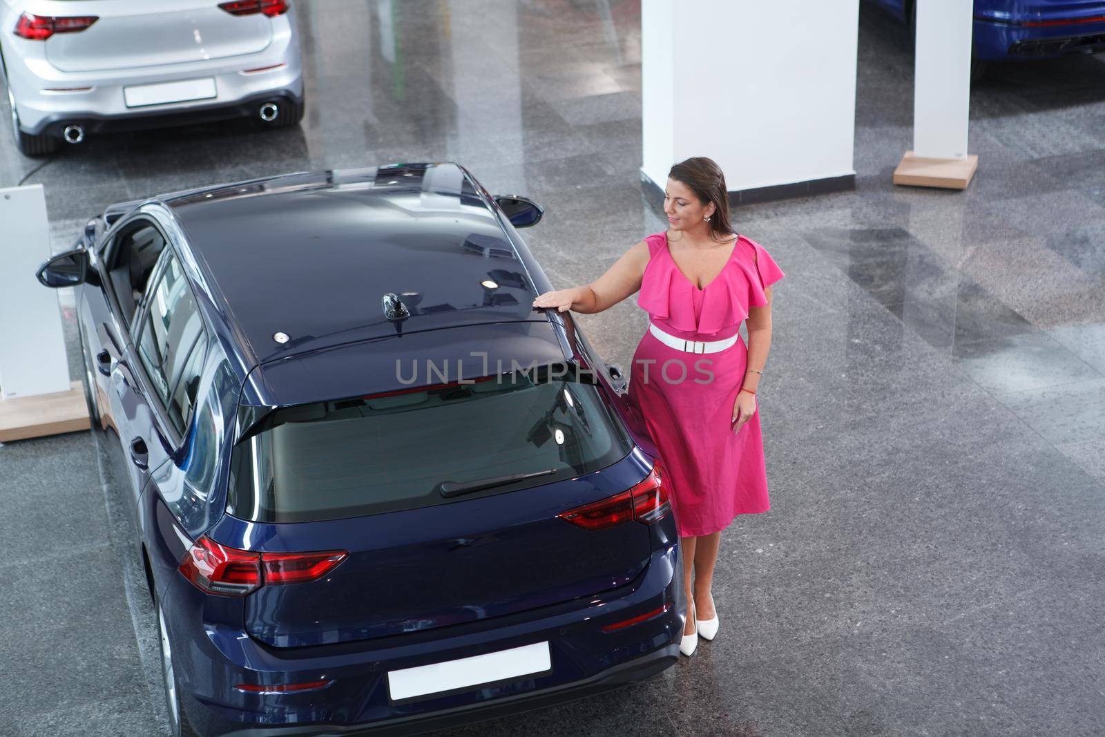 Elegant plus size woman looking at car for sale at dealership