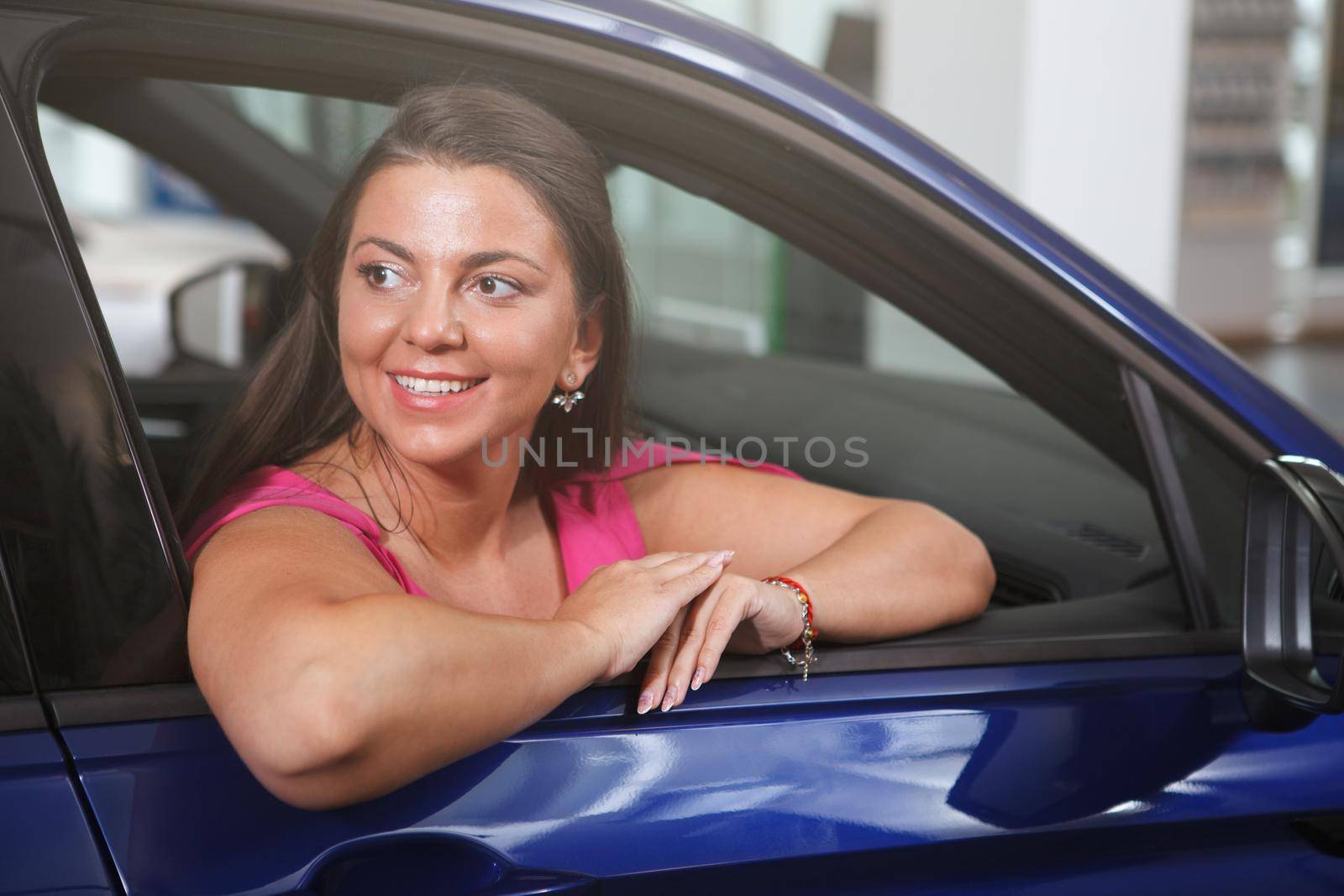 Lovely woman looking out of car window, smiling cheerfully